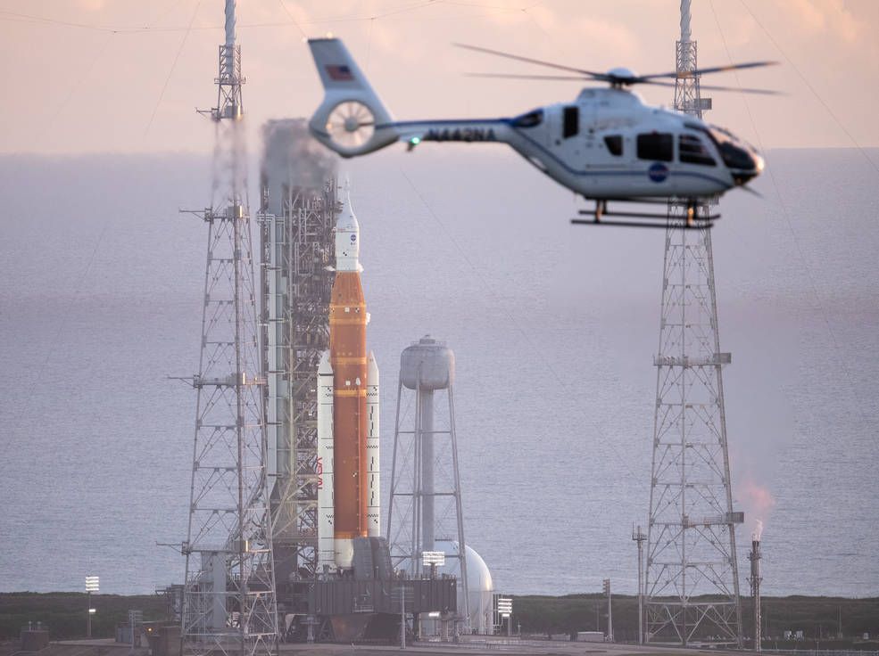 Un helicóptero de la NASA sobrevuela el cohete del Sistema de Lanzamiento Espacial (SLS) de la agencia con la nave espacial Orion a bordo del lanzador móvil en la plataforma de lanzamiento 39B en el Centro Espacial Kennedy de la NASA en Florida, este pasado lunes.