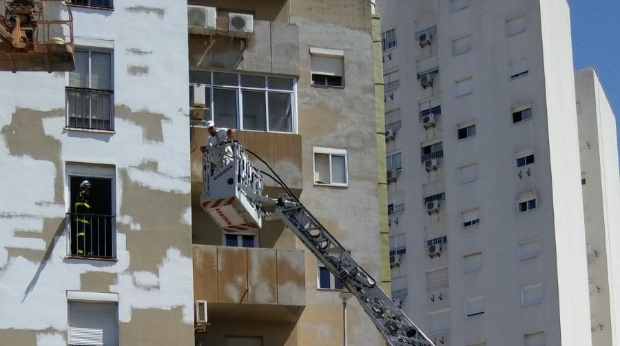 Trabajadores rescatados subidos en la grúa de los bomberos en Jerez. 