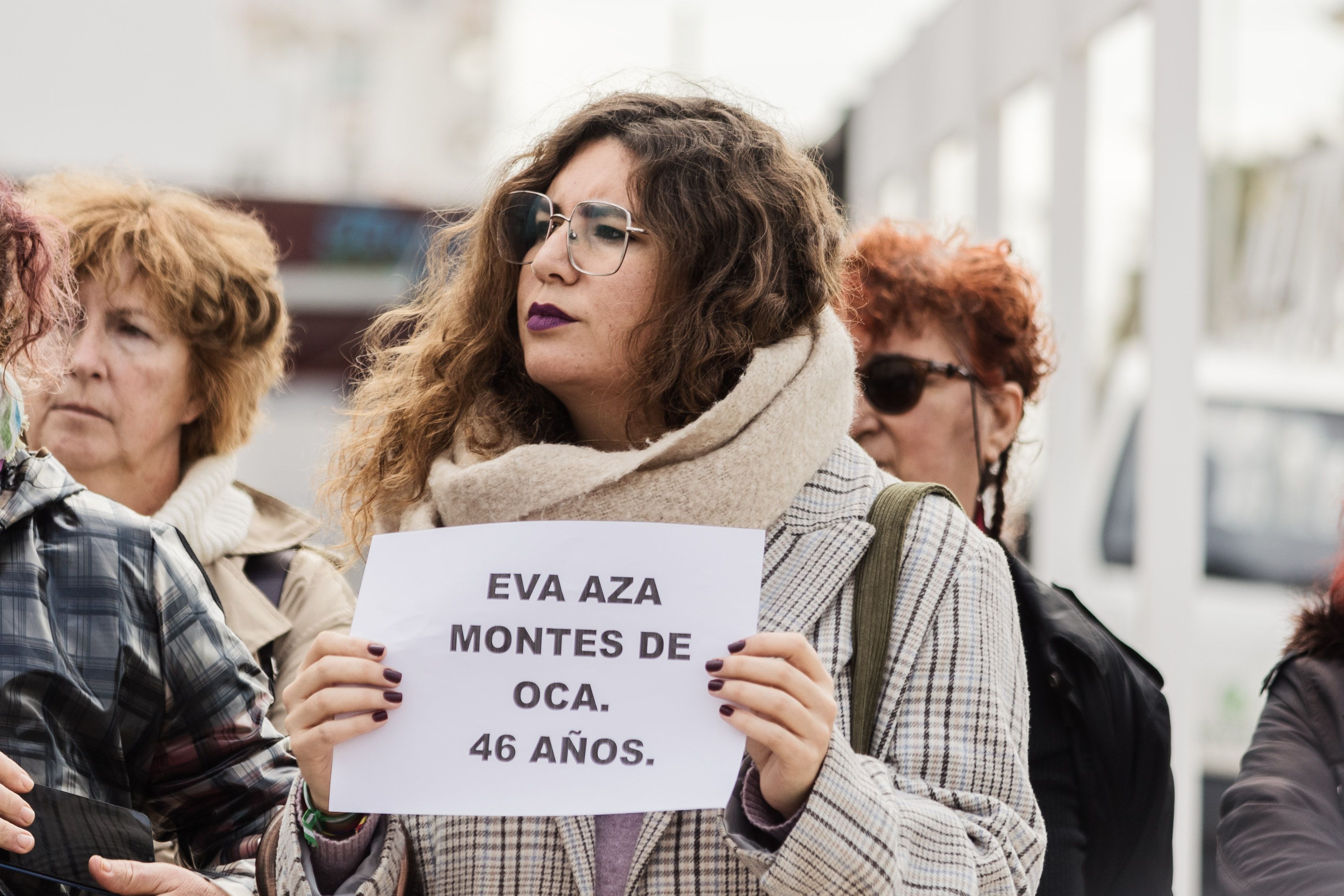 Una joven sujeta un cartel con el nombre de la mujer asesinada en El Puerto por su pareja.