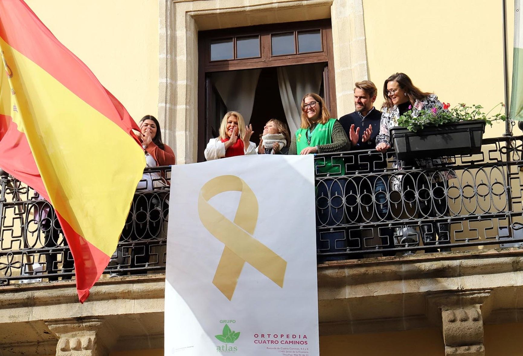 Colocación en el balcón del Ayuntamiento del lazo dorado por el cáncer infantil.