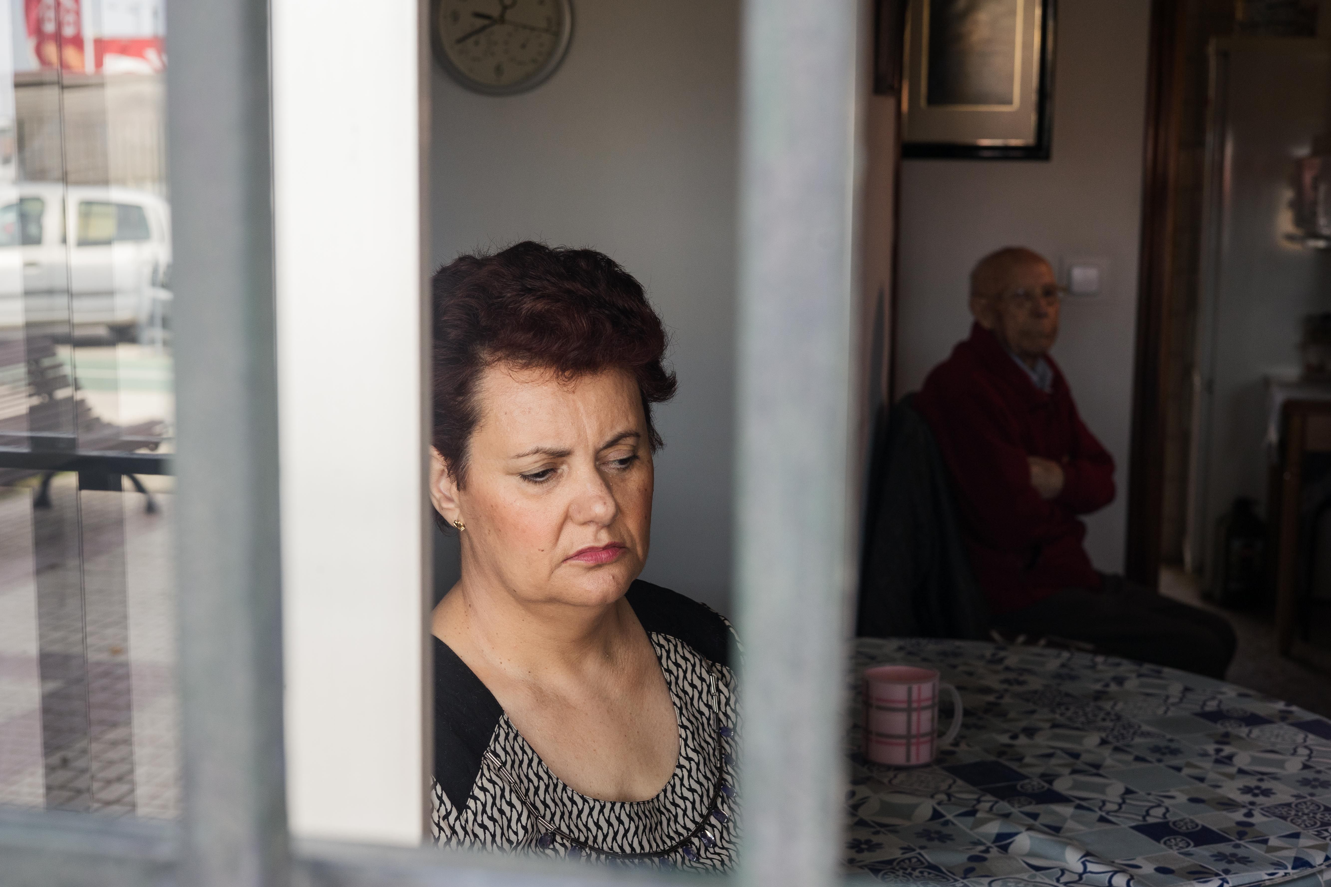 Mercedes Morón, ciega de nacimiento, en su casa, con su padre al fondo.