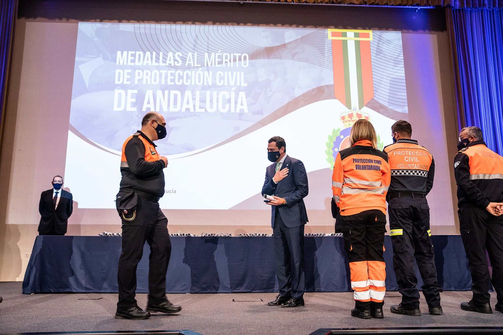 El presidente de la Junta, Juanma Moreno, otorgando la Medalla al Mérito a Protección Civil.