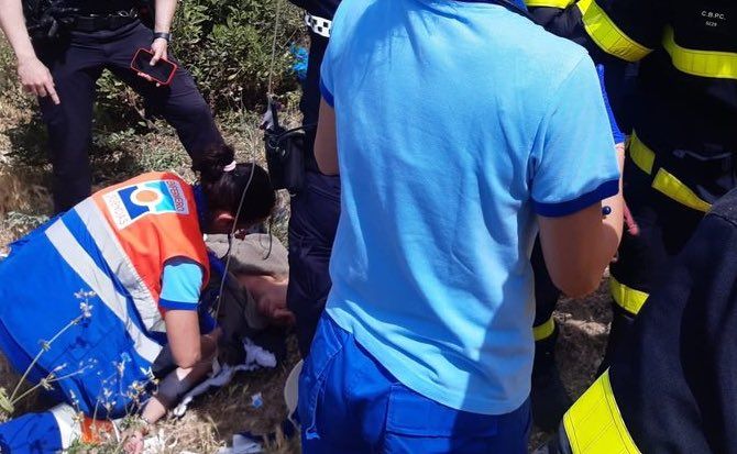 La mujer, siendo auxiliada tras caerse desde un muro.