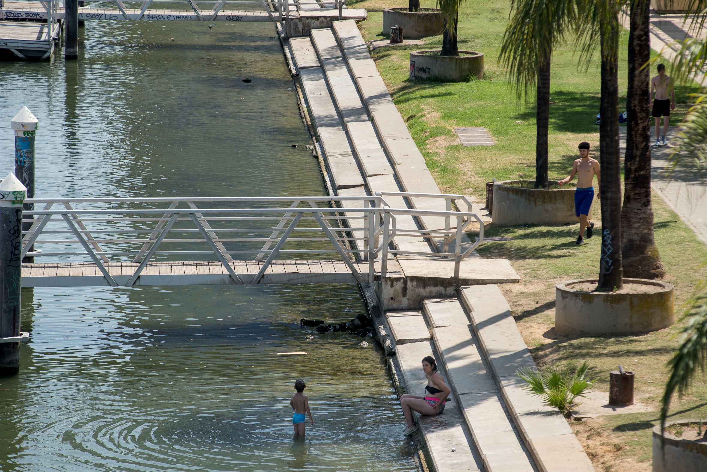 Personas en bañador en el río en Sevilla capital, una práctica que podría conllevar multa con la nueva ordenanza.