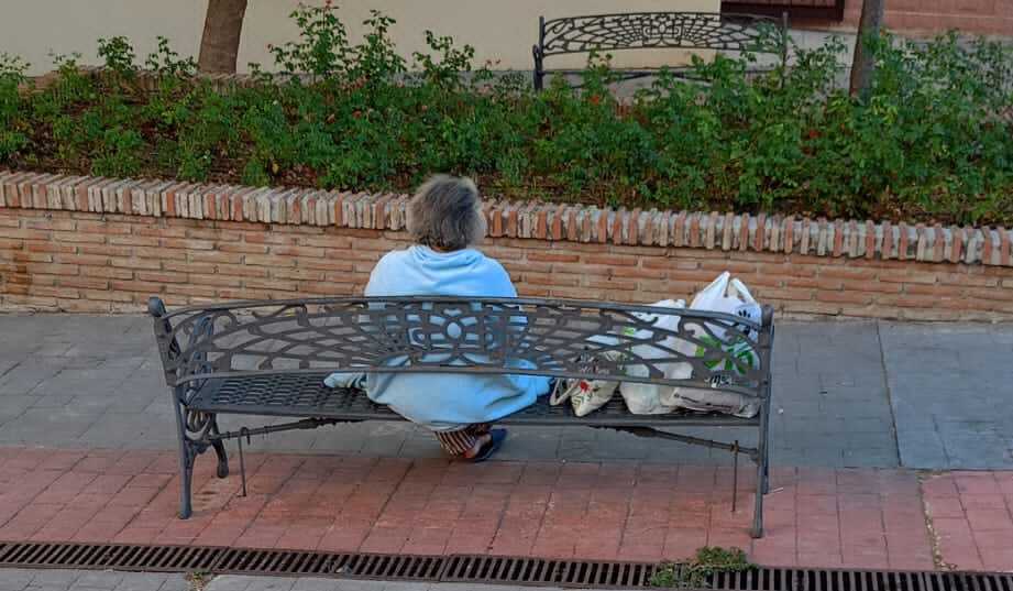 La mujer, de espaldas, que necesita ayuda al vivir frente a una iglesia desde hace seis meses, en una imagen compartida en redes por Andrés Ruiz.