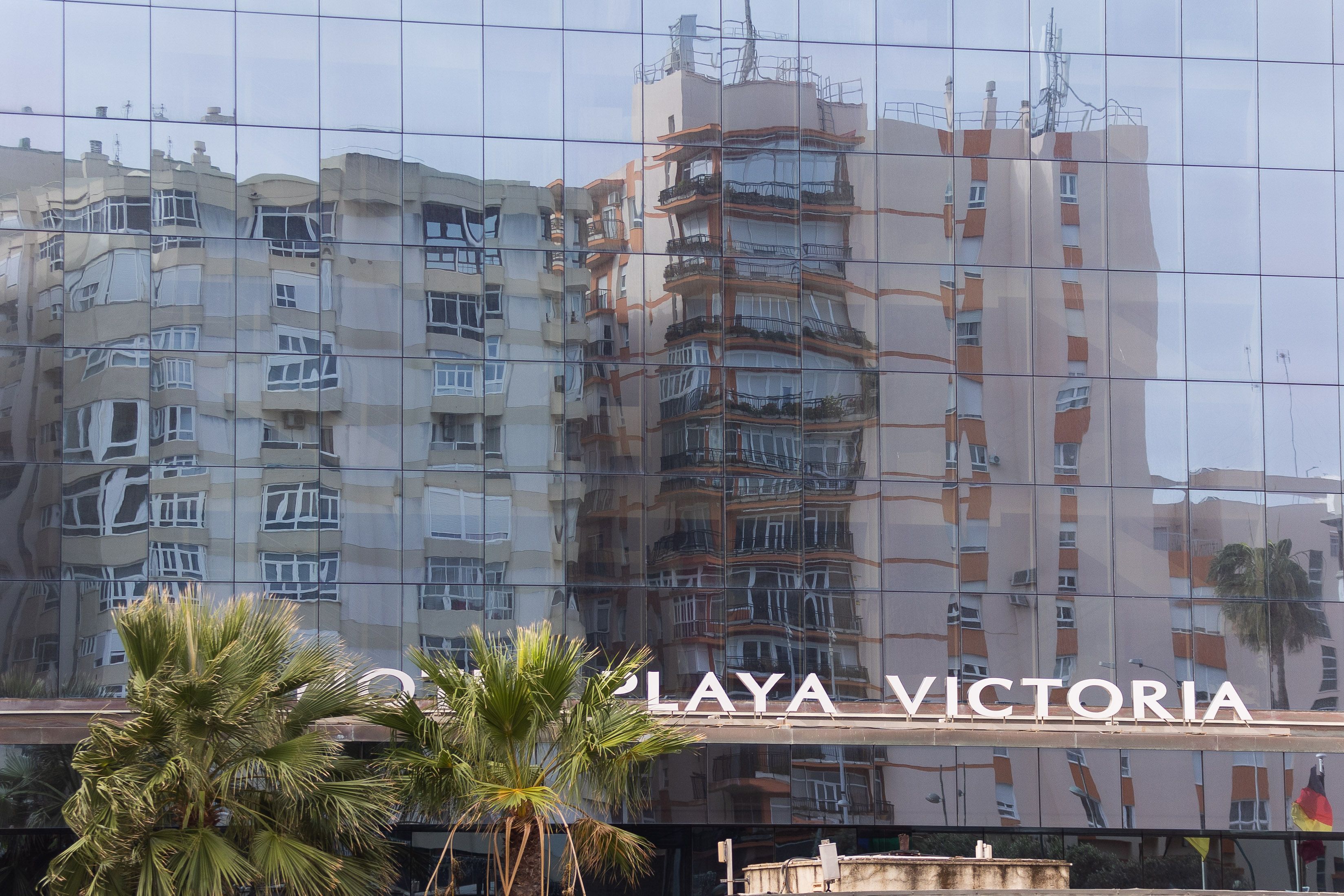 Fachada del hotel Playa Victoria, con pisos junto al mar reflejados, en Cádiz, en una imagen de archivo.