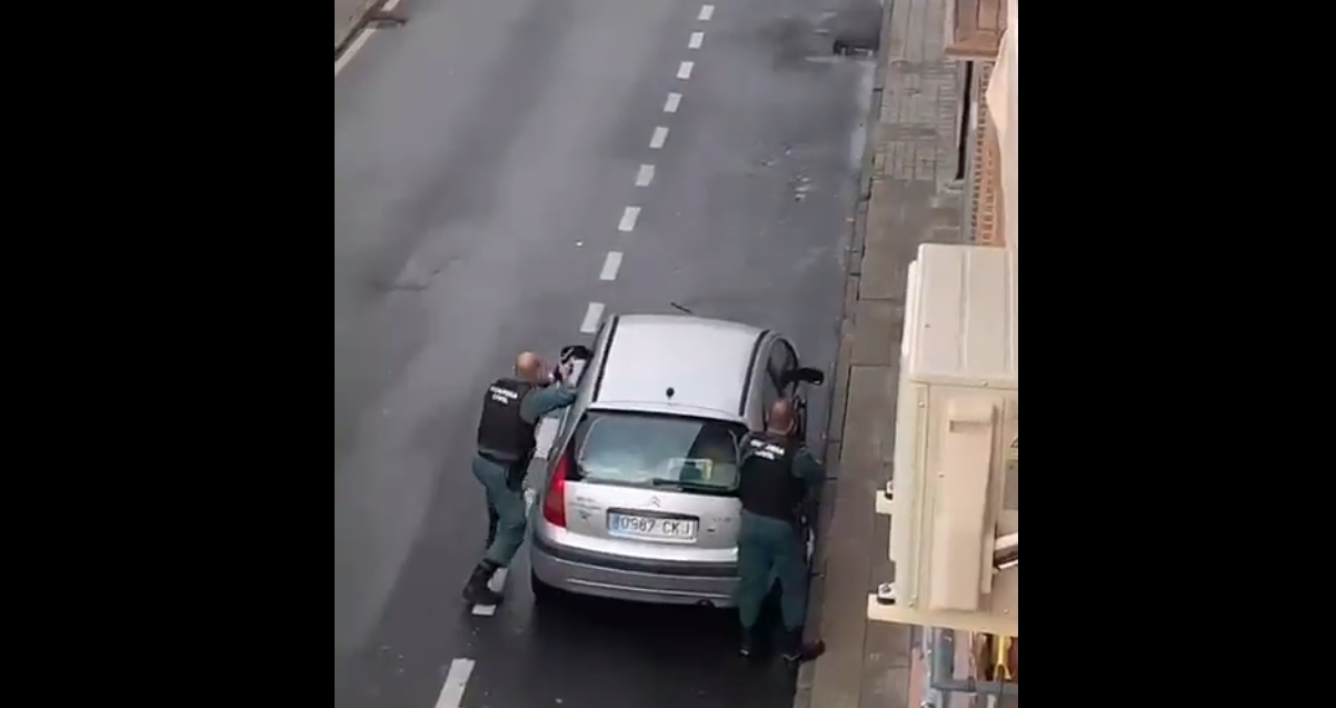 Agentes de la Guardia Civil, parapetados tras un coche.