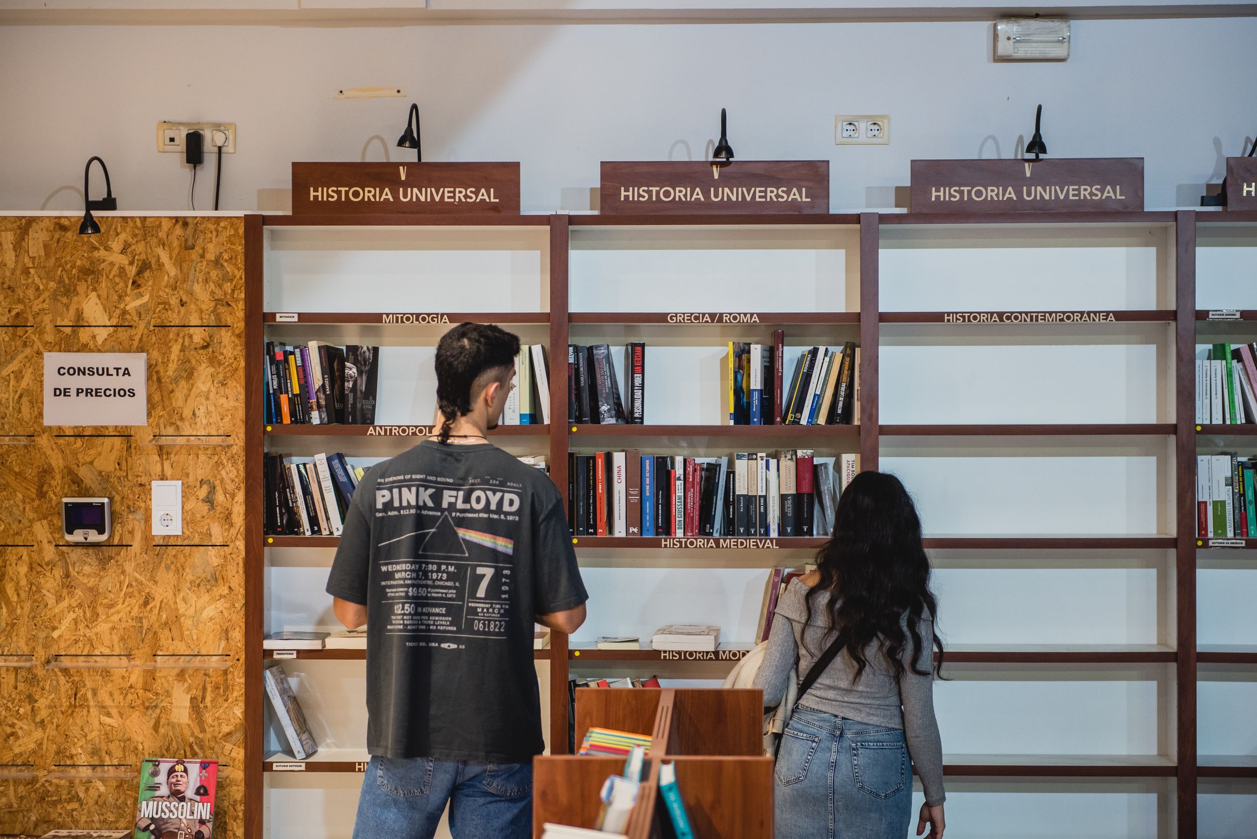 Dos jóvenes buscan libros en una librería.