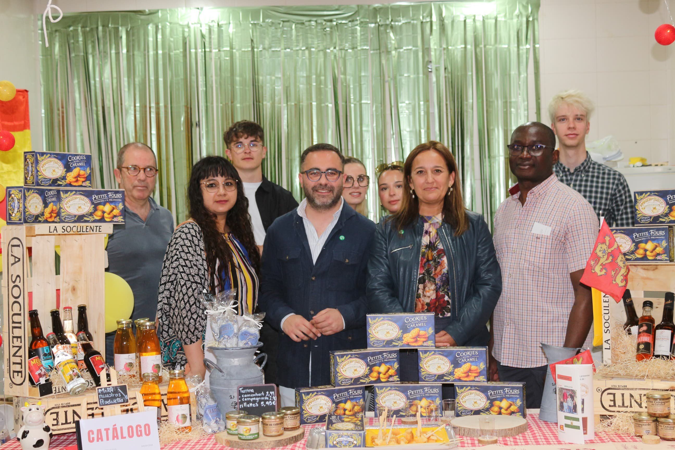 Estudiantes de la Universidad Politécnica Francesa de Cherburgo, junto a sus profesores, dan a conocer los productos más típicos de su región a todas las personas usuarias del mercado.