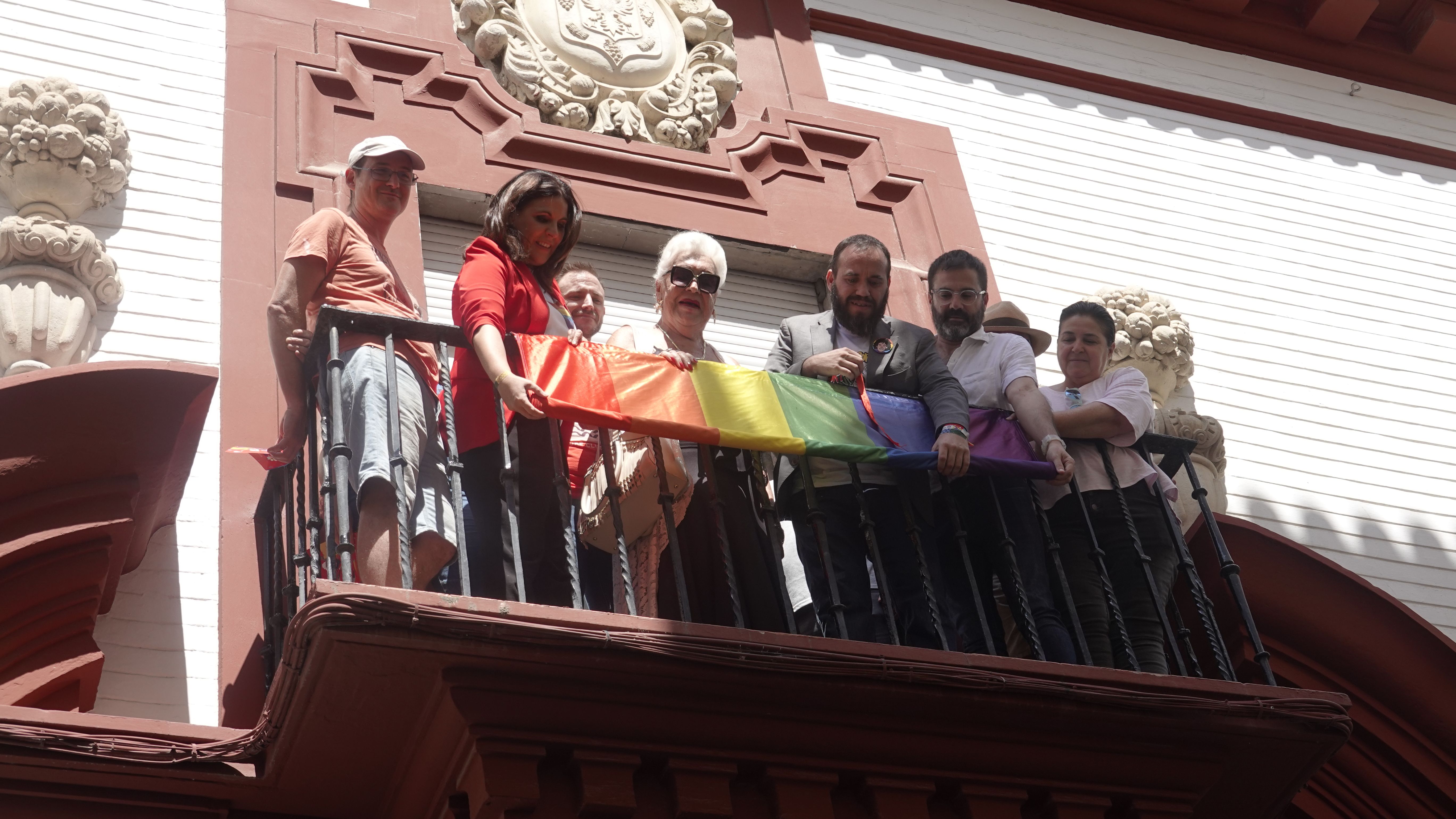 Manolo Rosado en el centro de la imagen izando la bandera LGTBI.
