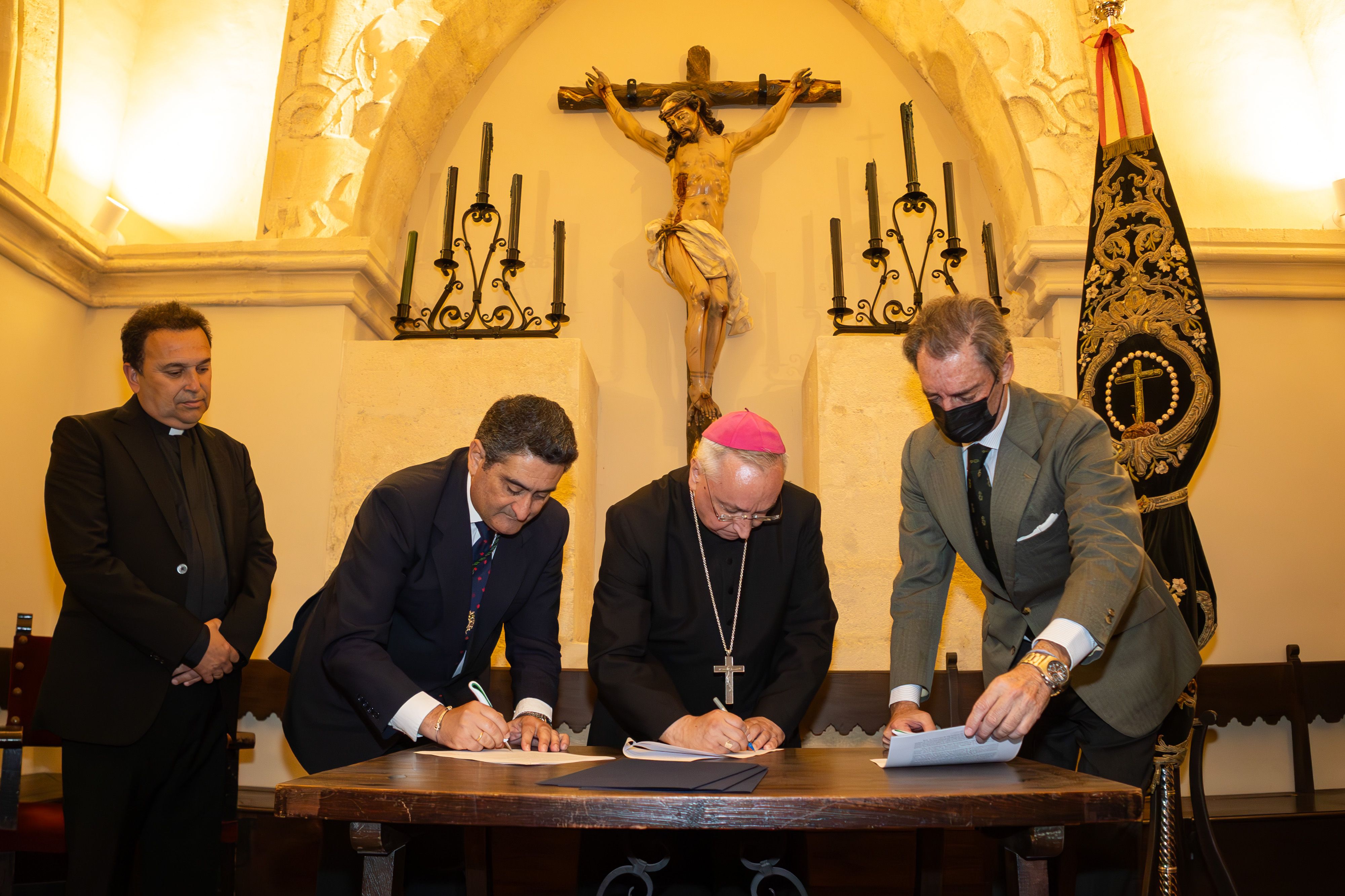 El obispo, el hermano mayor y el presidente de la Fundación firmando el convenio en la capilla de la Jura.