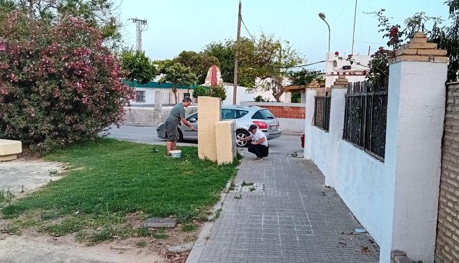 Dos vecinos, pintando en la barriada San Enrique.