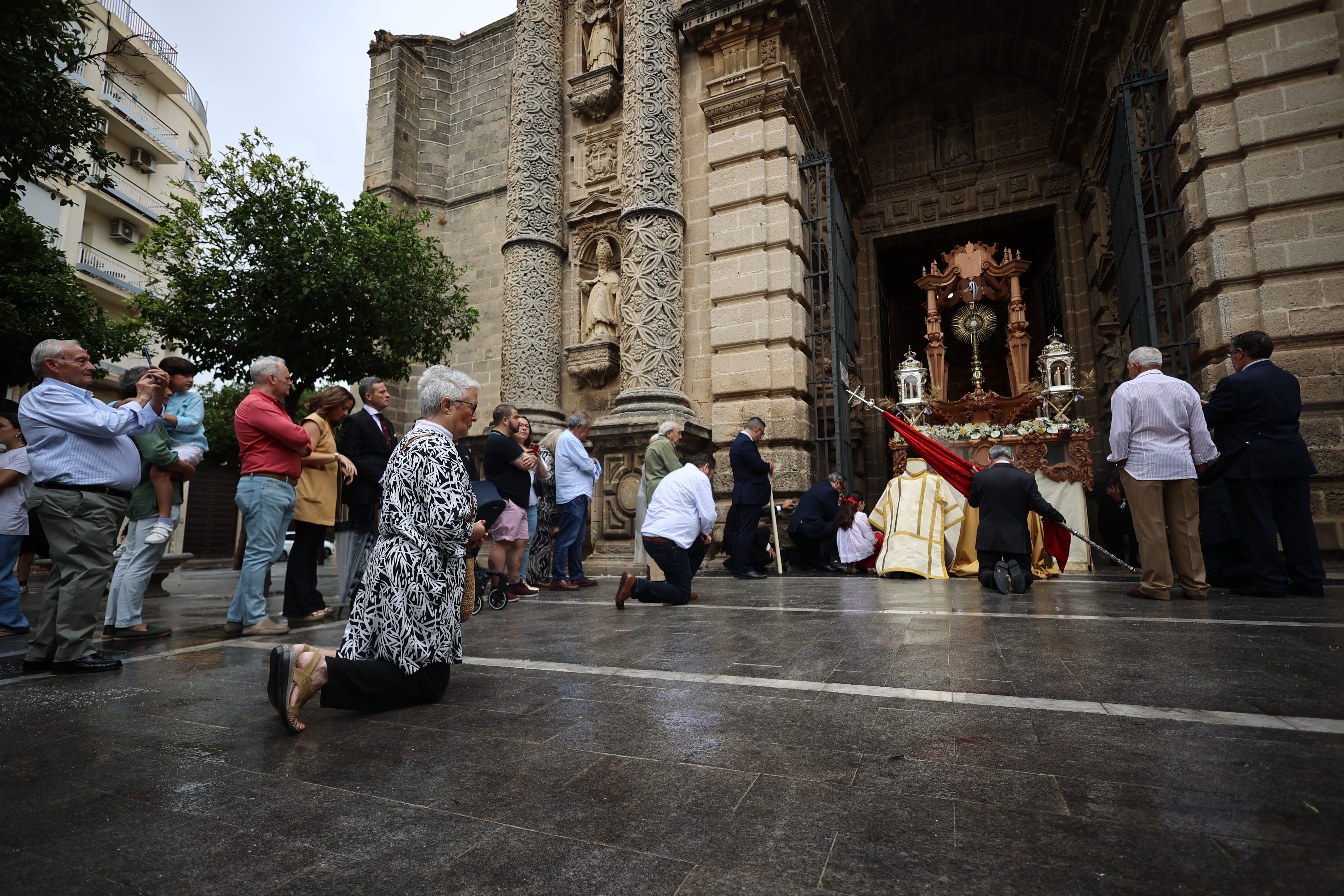 Un grupo de fieles reza a Jesús Sacrificado a las puertas de San Miguel.