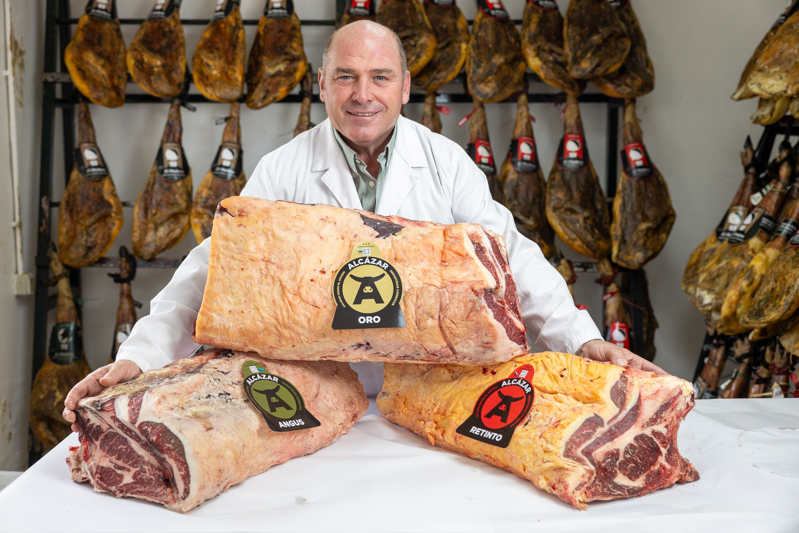 Isaac Ortega, uno de los hermanos de Cárnicas Alcázar, junto a alguna de las carnes que vende.