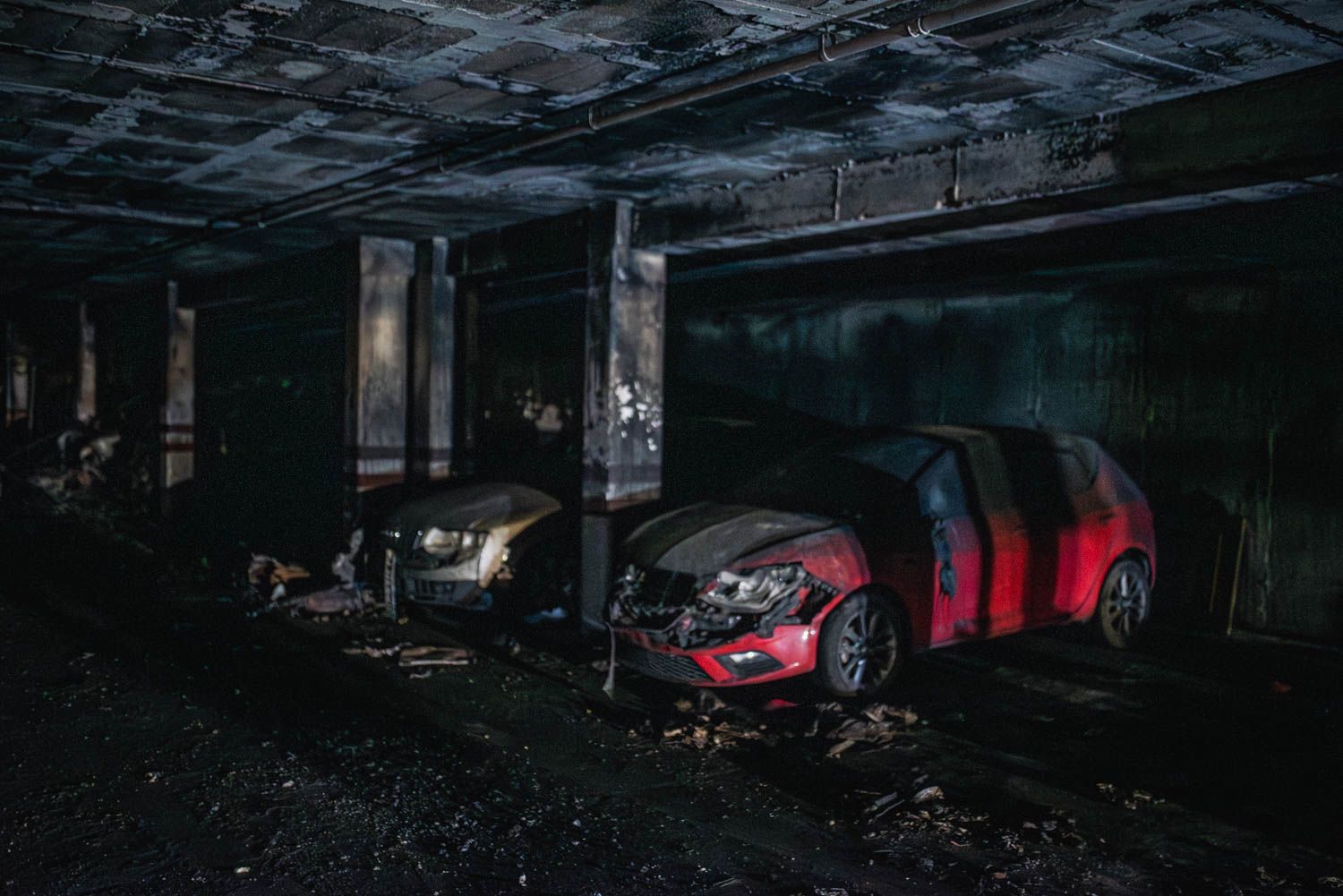 Varios coches afectados por el incendio de Pino Montano, aún en el garaje, este lunes.