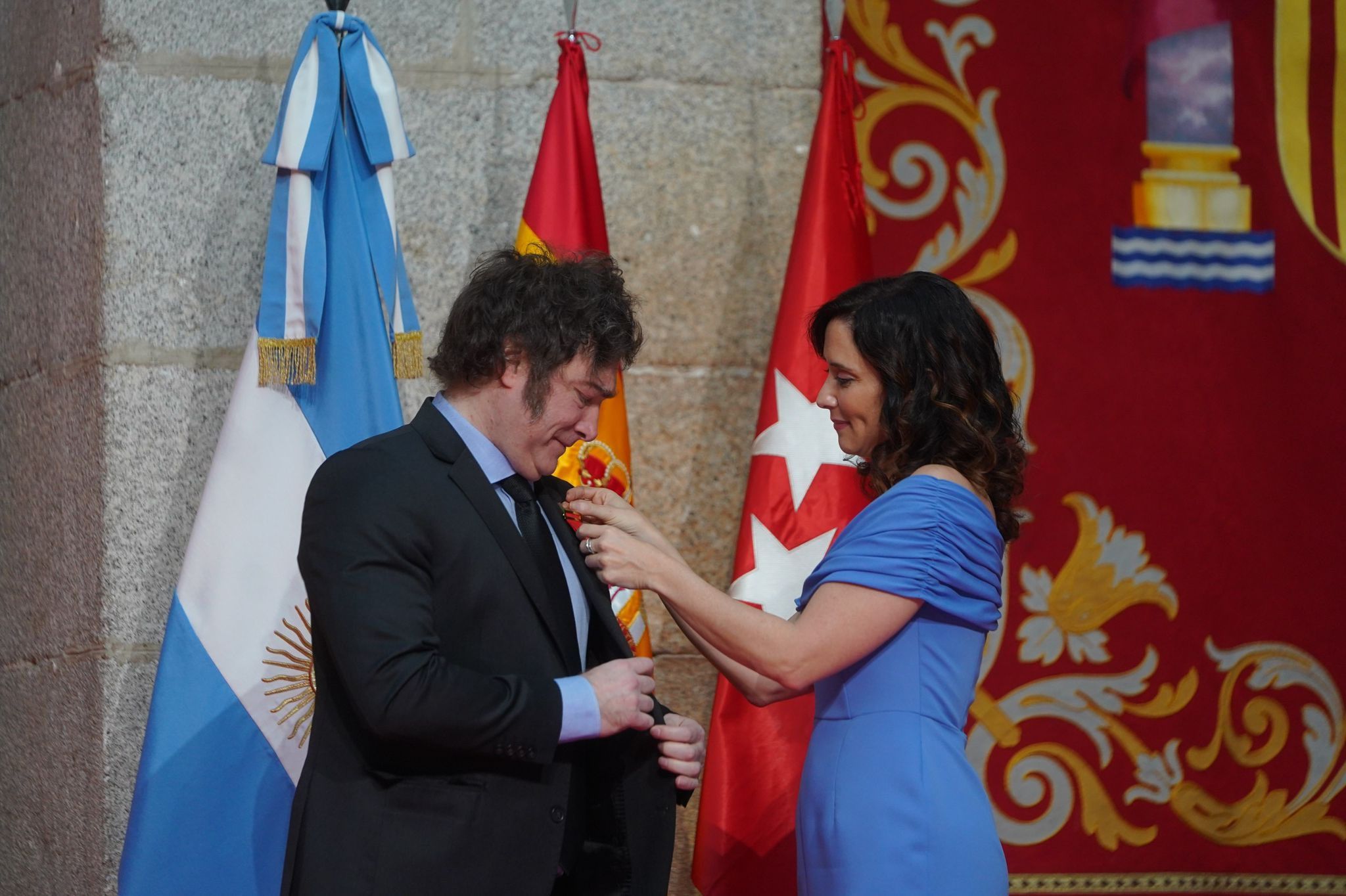 Ayuso, colocando la Medalla Internacional de Madrid a Milei.