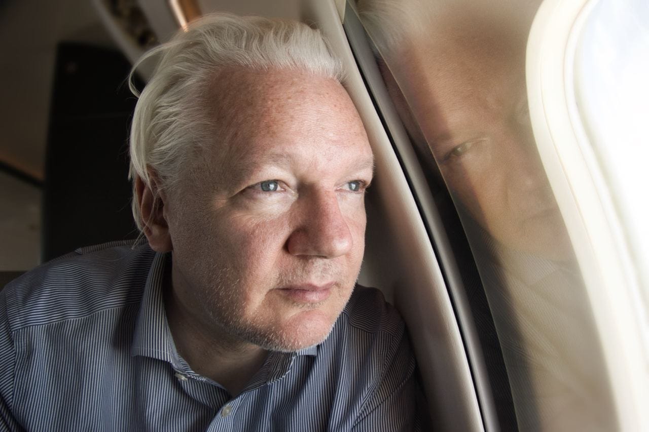 Julian Assange, en el avión que lo traslada a las Islas Marianas.