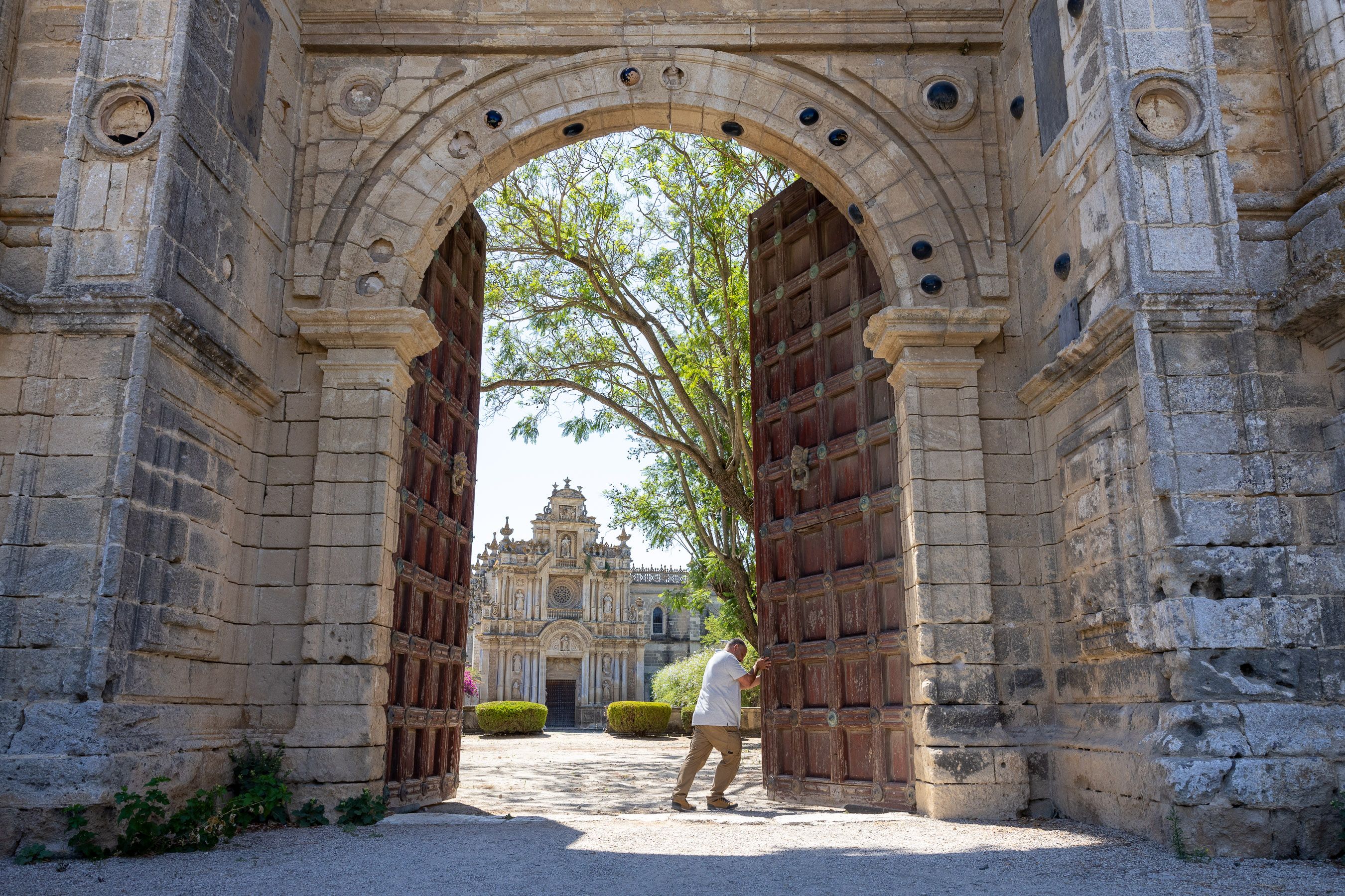 Un trabajador de mantenimiento, abriendo las puertas del monasterio de la Cartuja.