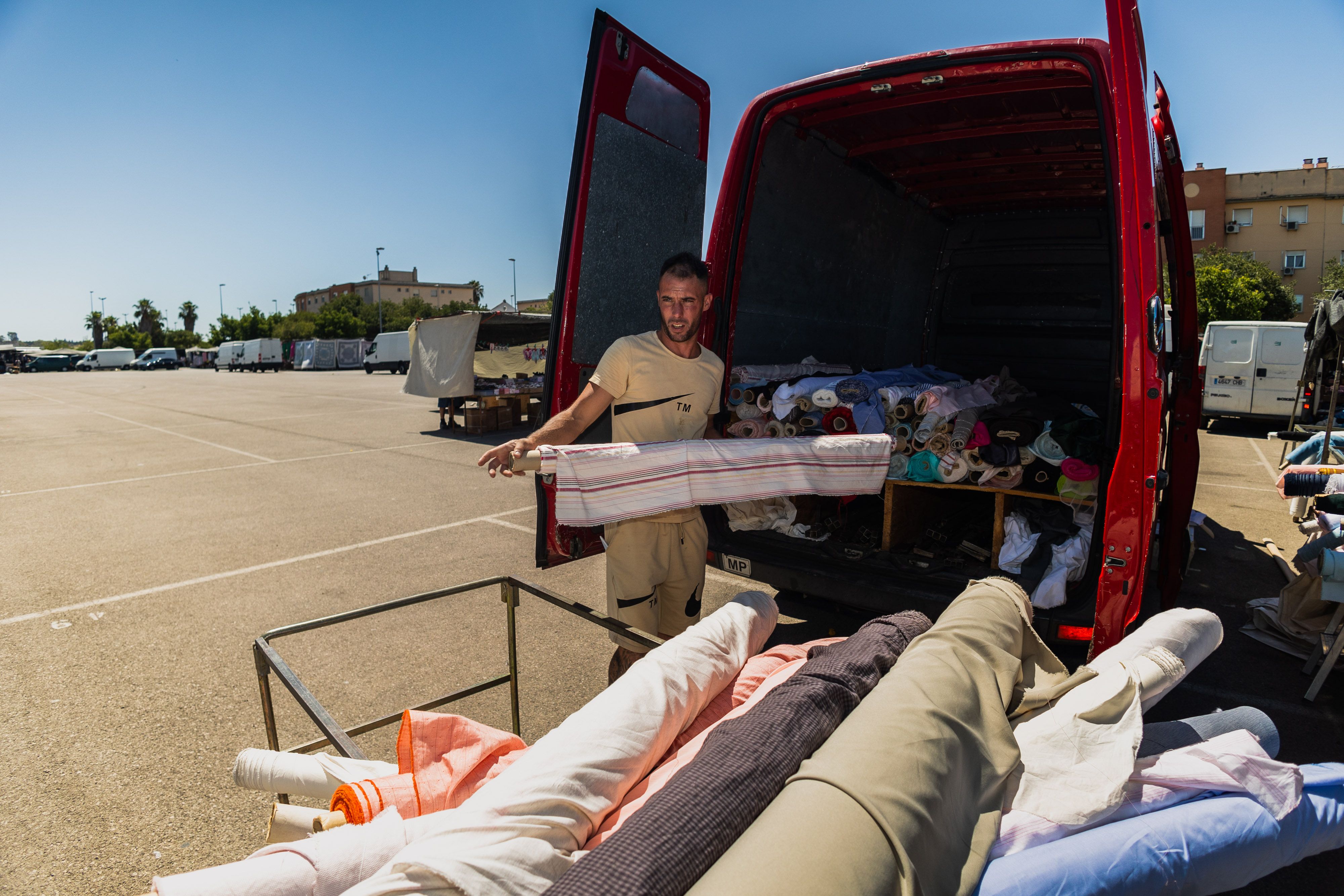Sergio, trabajador de un puesto de venta de textiles, cargando la furgoneta con la mercancía recogida. 
