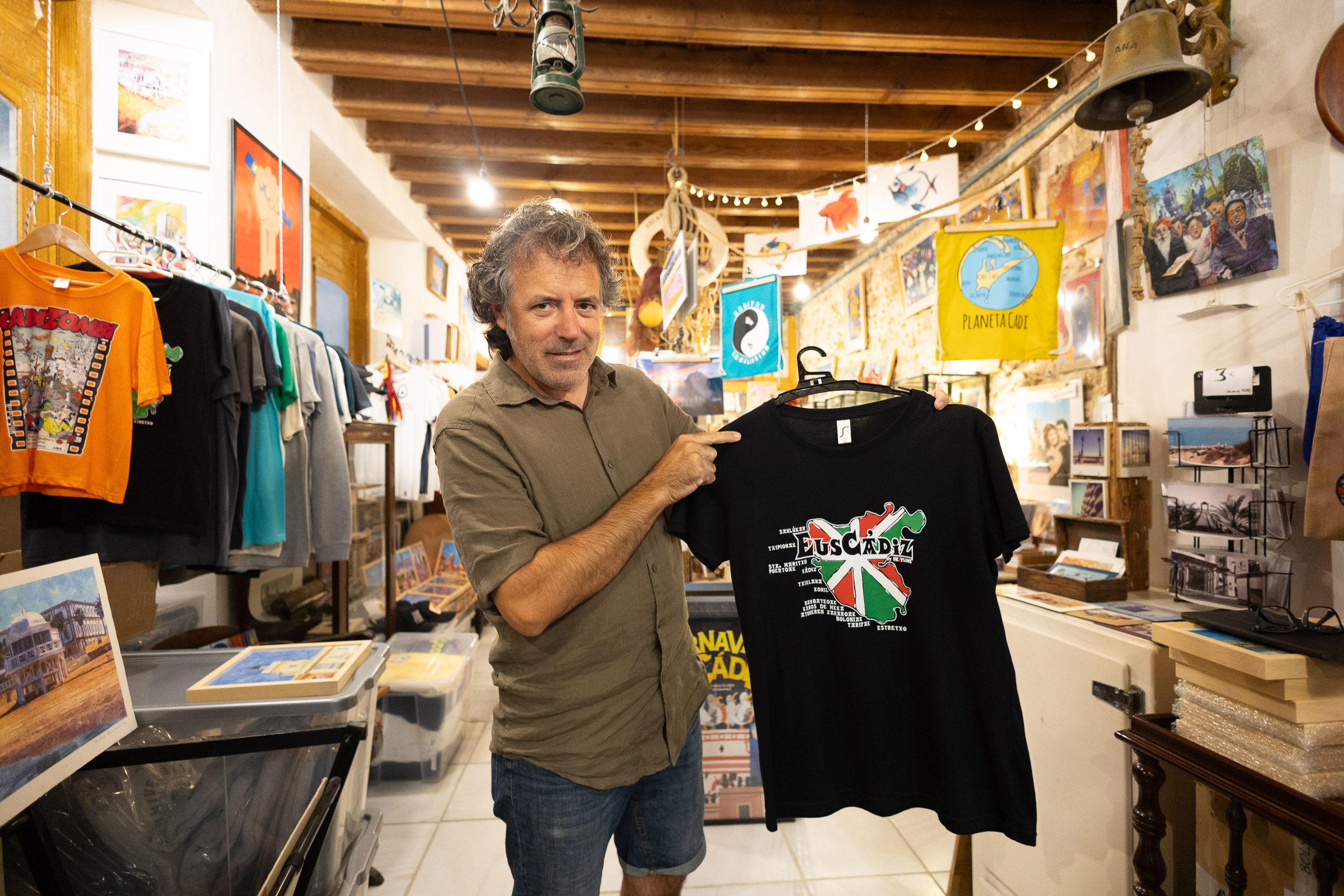 Javier Benítez muestra uno de sus diseños más populares, 'EusCádiz', en el centro de su tienda en la calle José del Toro.
