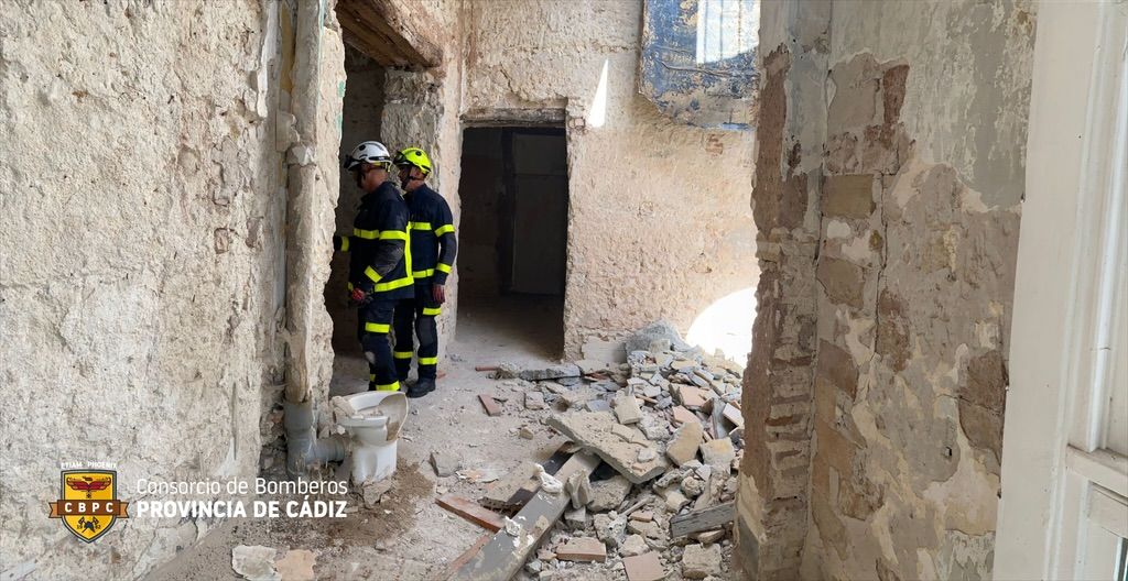 Imagen de los bomberos rodeados de los escombros caídos en el edificio de Cádiz.