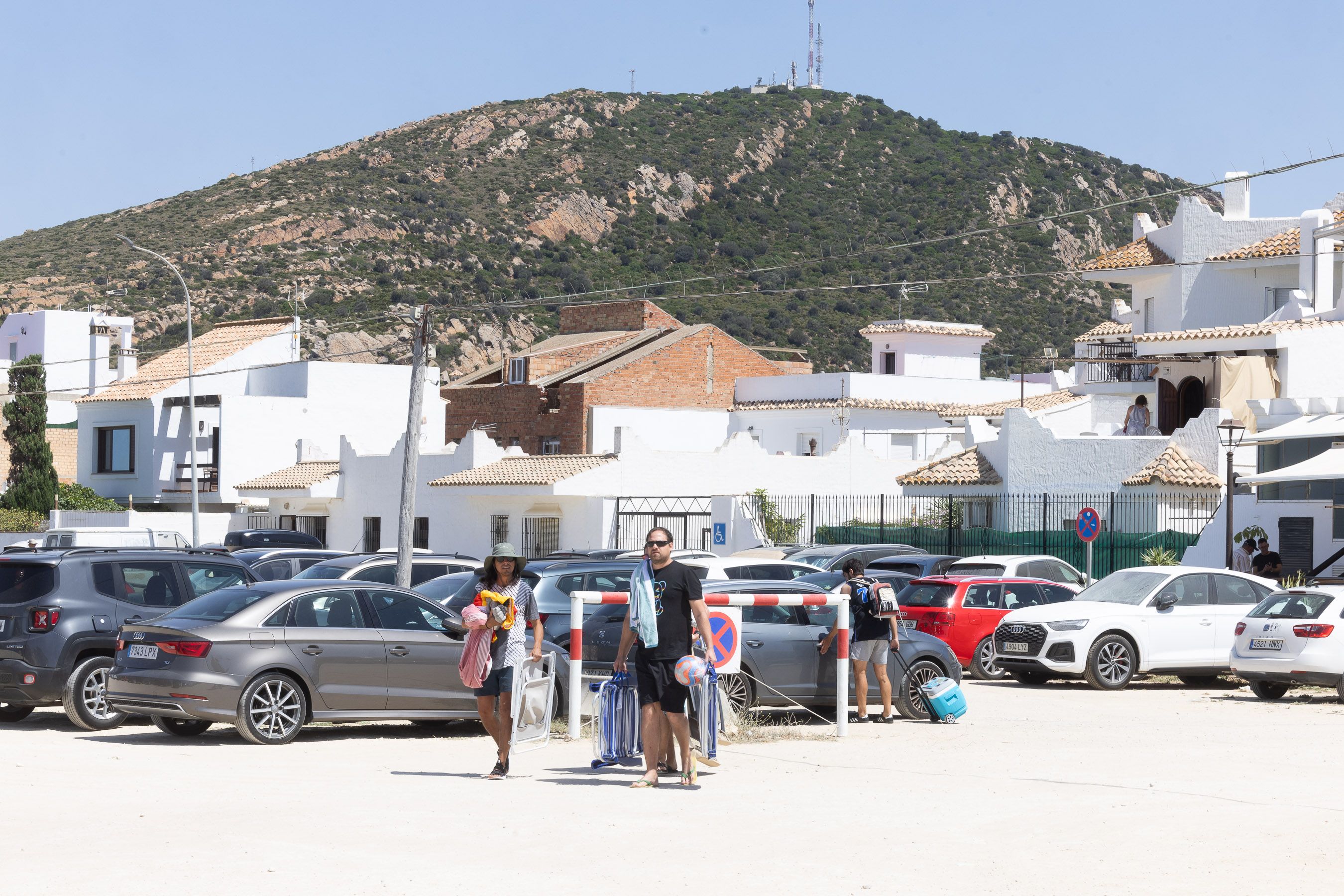 Veraneantes llegan a la playa de Zahara con la sierra del Retín al fondo.