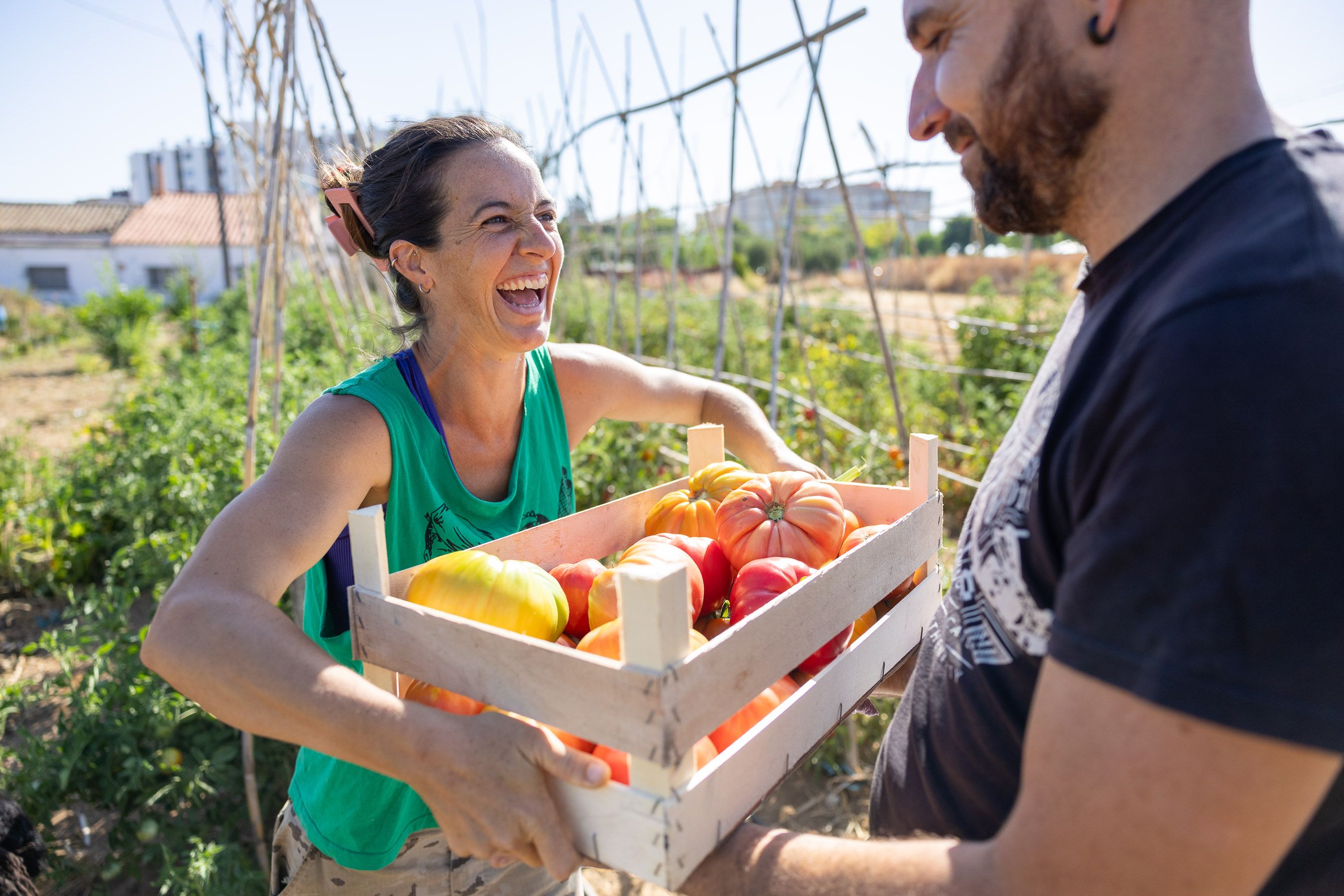 Charo y José con una caja llena de verduras.