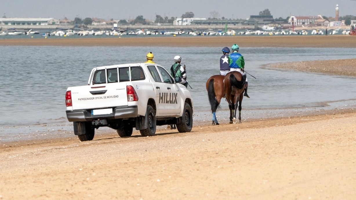 Nimo Grupo y las carreras de caballos de Sanlúcar. Un vehículo Toyota en las arenas de la playa tras unos jinetes.