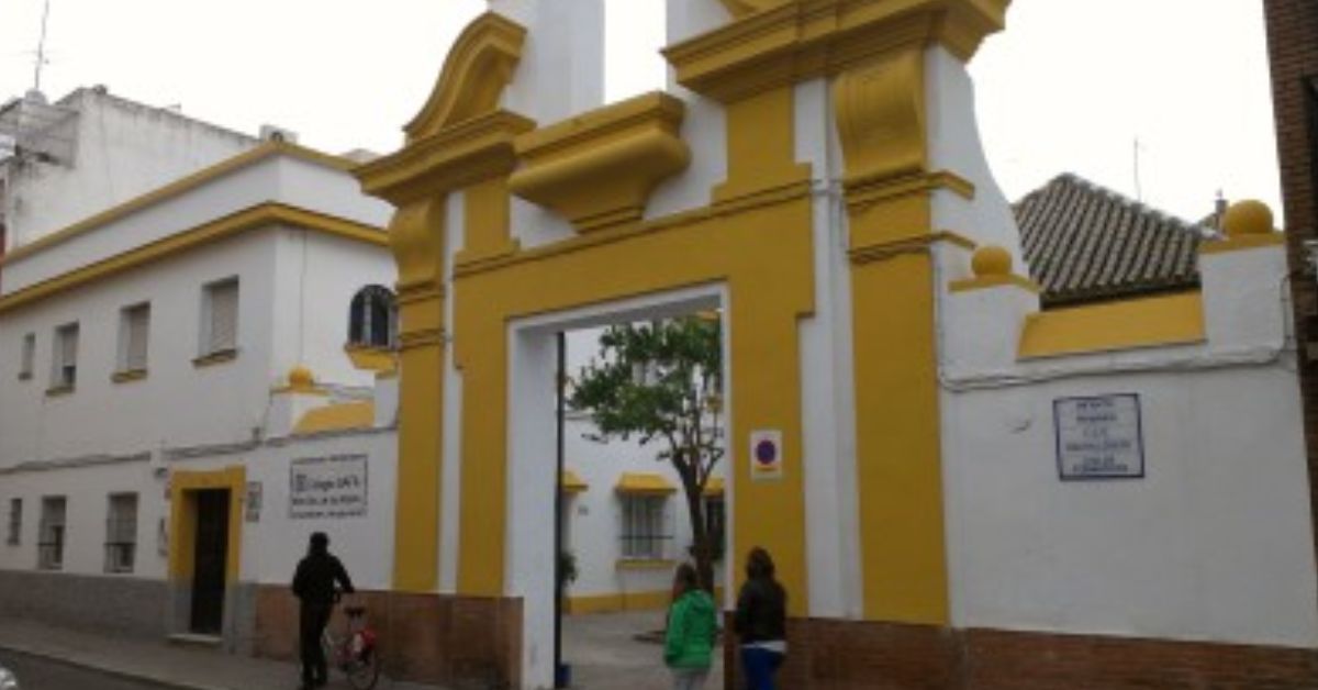 La fachada principal del colegio a la que se ha subido un joven.