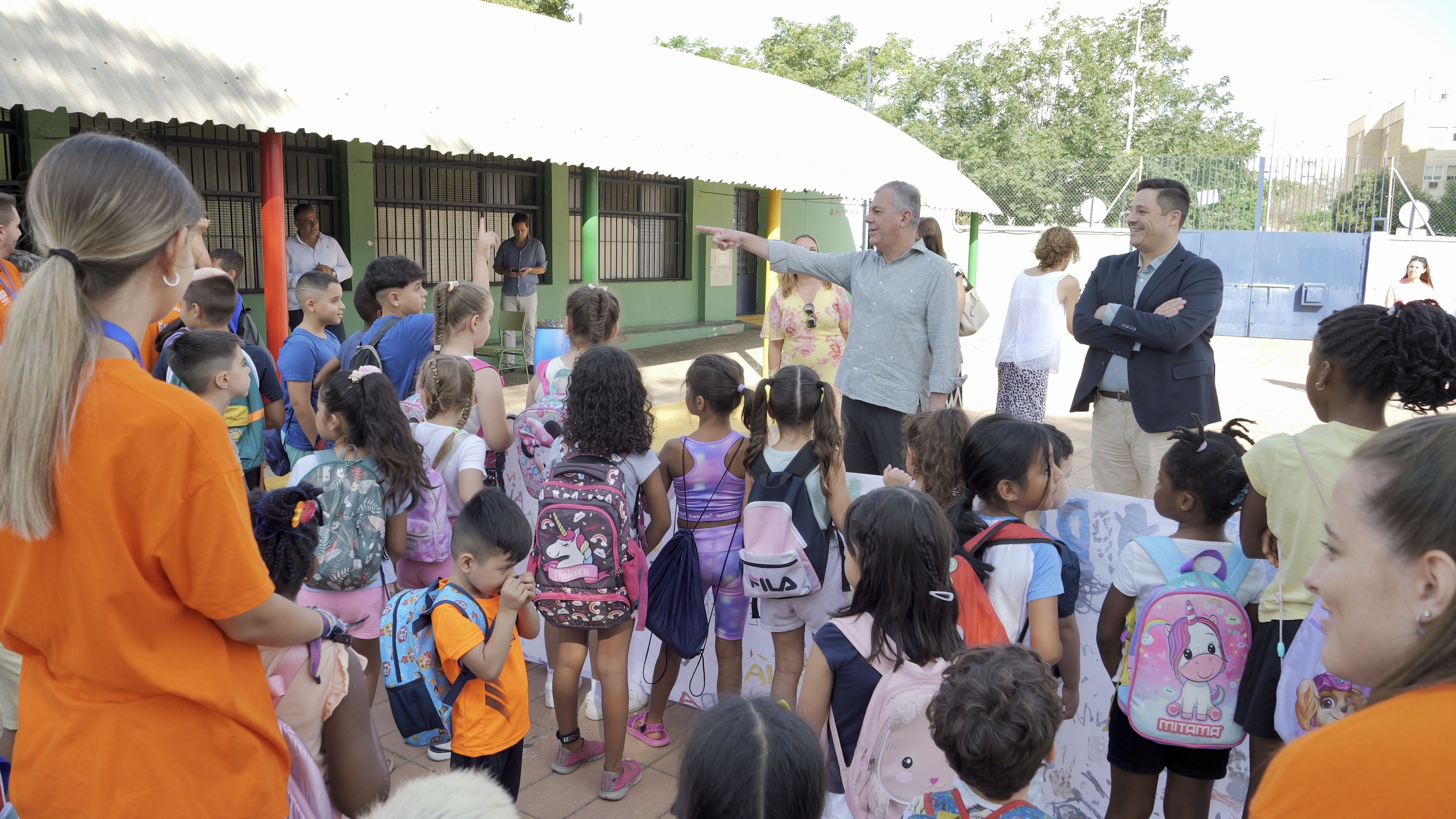 Sevilla atiende a más de 1.700 menores. El alcalde durante la visita al centro educativo junto a niños y niñas que participan en el programa. 