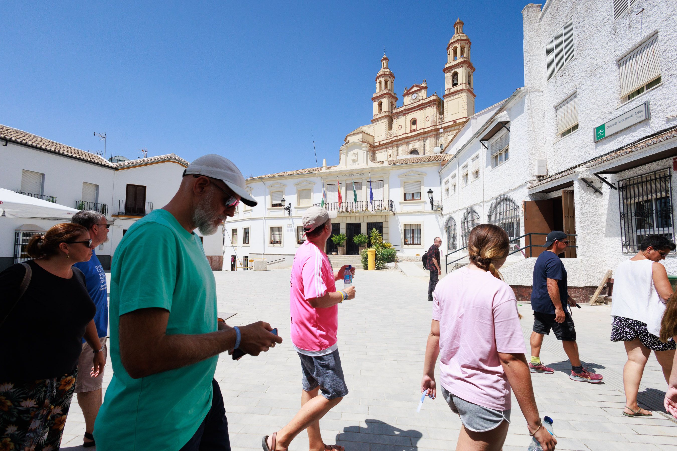 Un grupo de turistas, por la plaza del Ayuntamiento de Olvera en este mes de agosto.