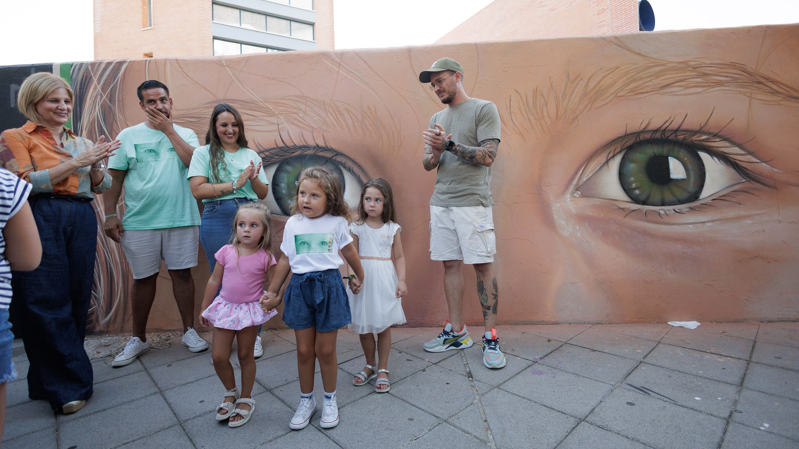 Valentina, la pequeña con camiseta blanca, delante del mural que le hizo Cosa.V.