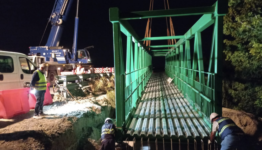 Operarios durante la pasada noche trabajando en la colocación de la pasarela. 