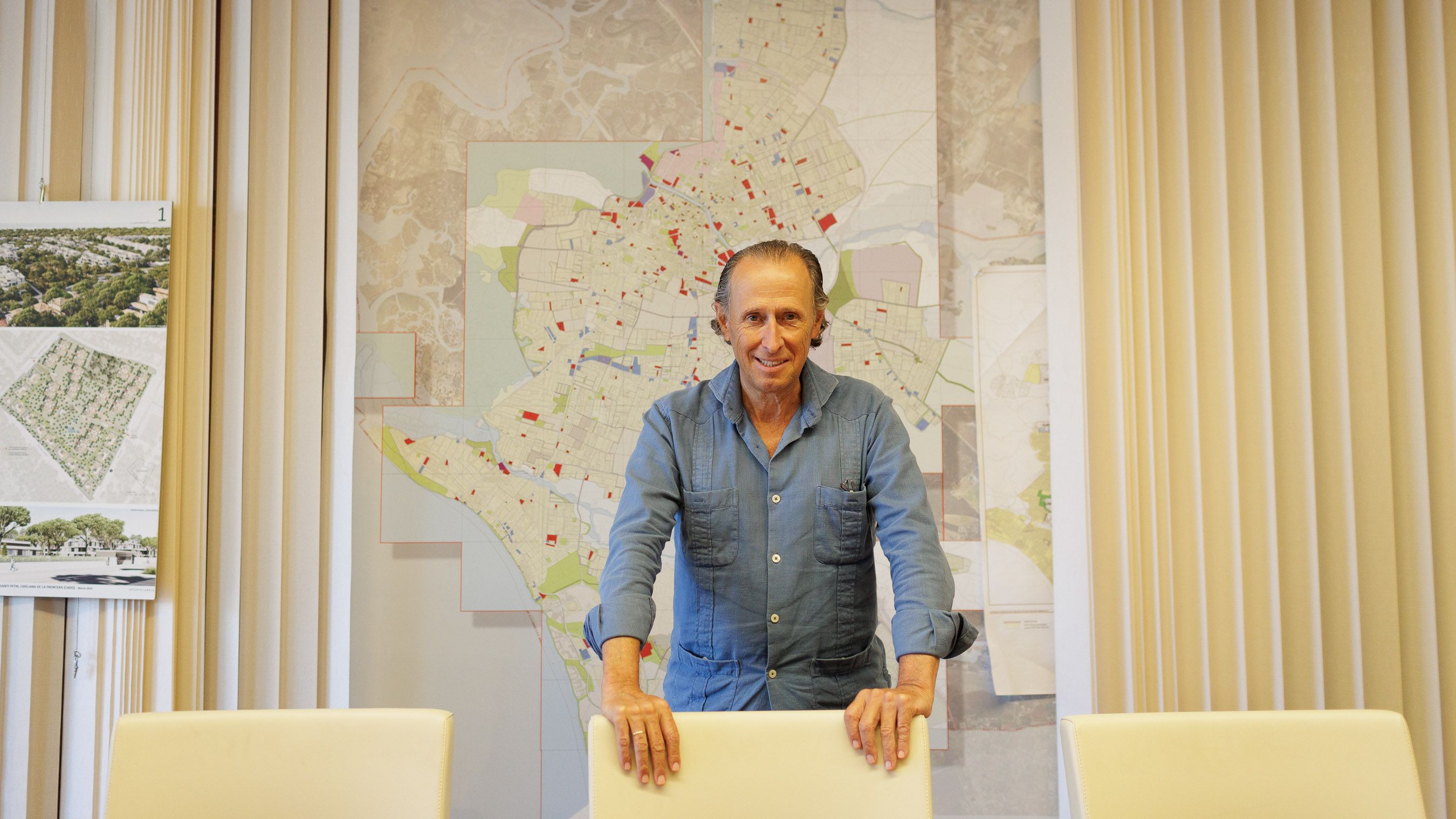 Jose María Román, alcalde de Chiclana, con el mapa de su despacho detrás.