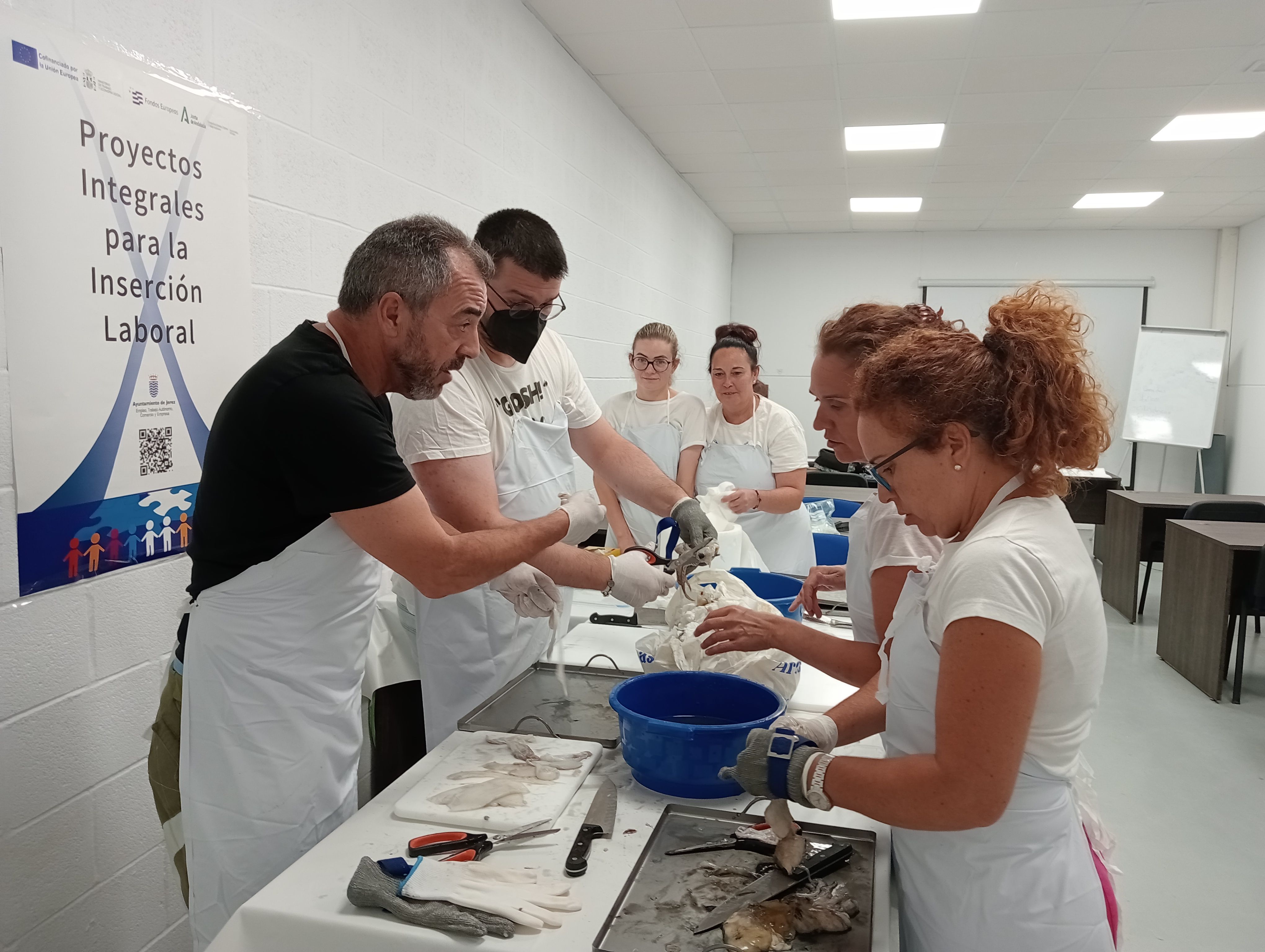 Alumnos del programa de inserción laboral durante las prácticas en pescadería. 