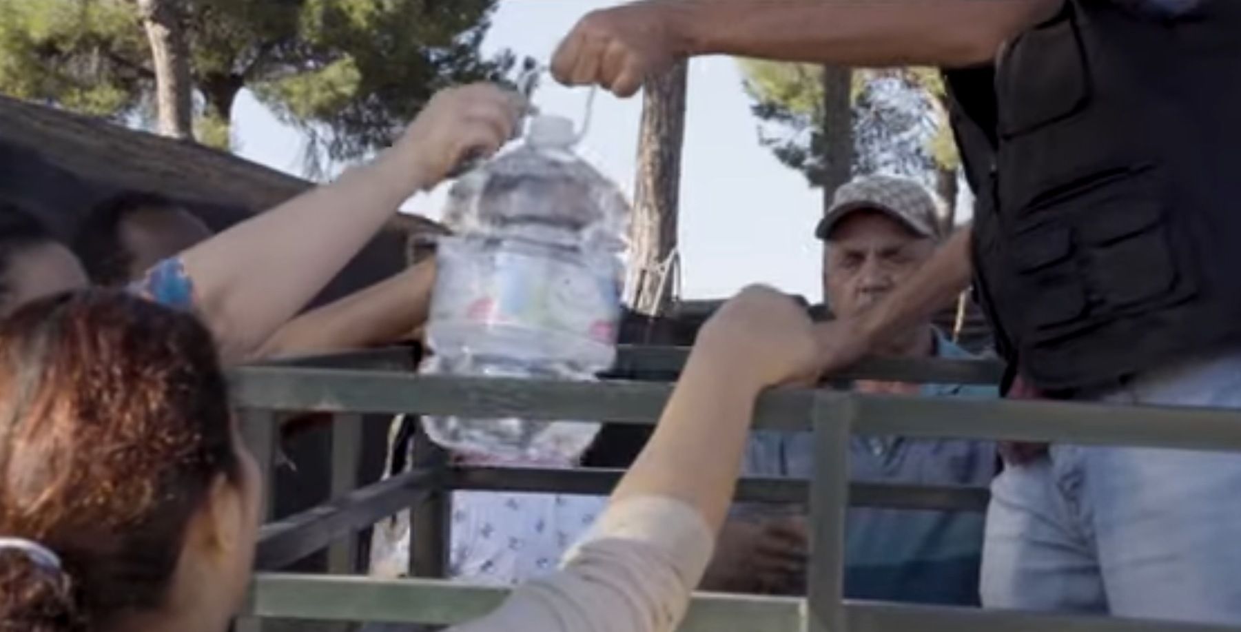 Reparto de agua entre los migrantes que han trabajo de temporeros en Huelva.