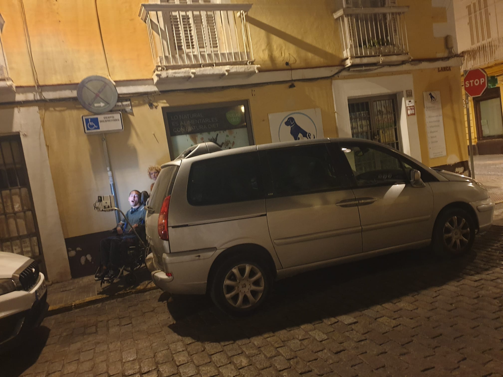 Vehículo estacionado en la plaza para personas con movilidad reducida en la calle Larga, en El Puerto.