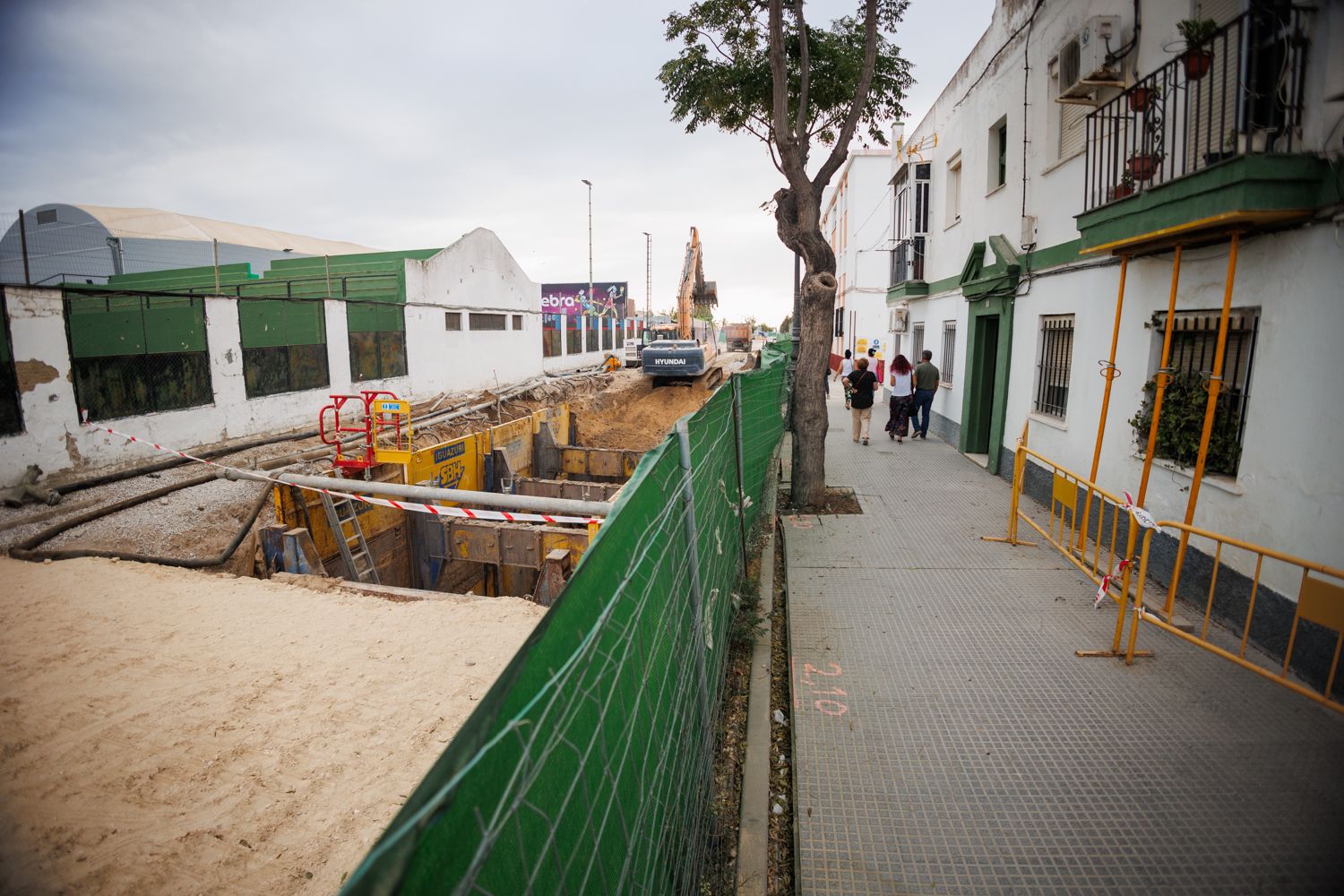 Los vecinos caminan junto a la obra del tanque de tormentas en la avenida de la Bajamar, en El Puerto.