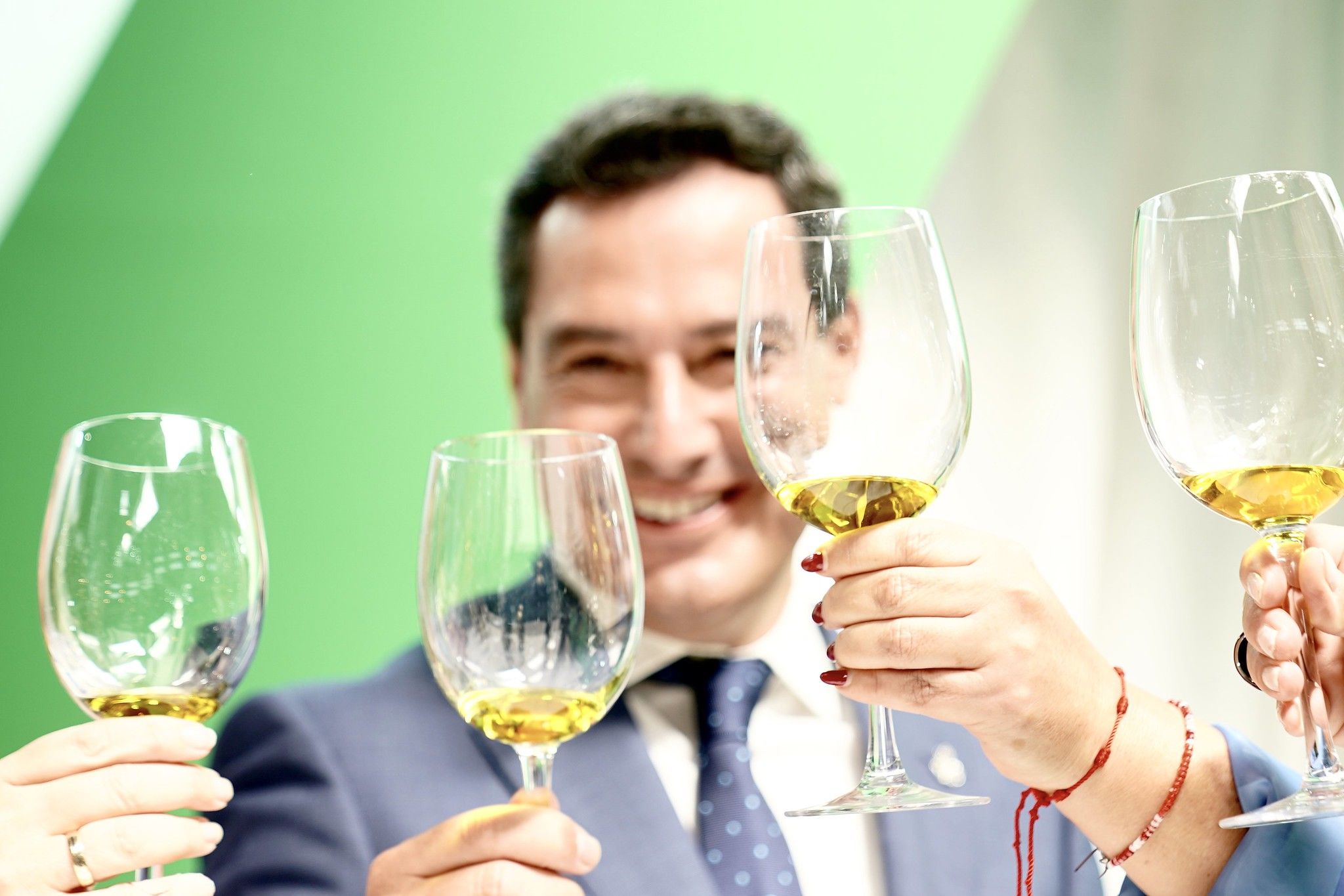 El presidente de la Junta de Andalucía, Juan Manuel Moreno, brindando con aceite de oliva.