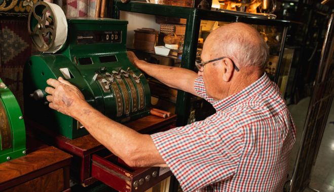 Con una antigua máquina registradora.