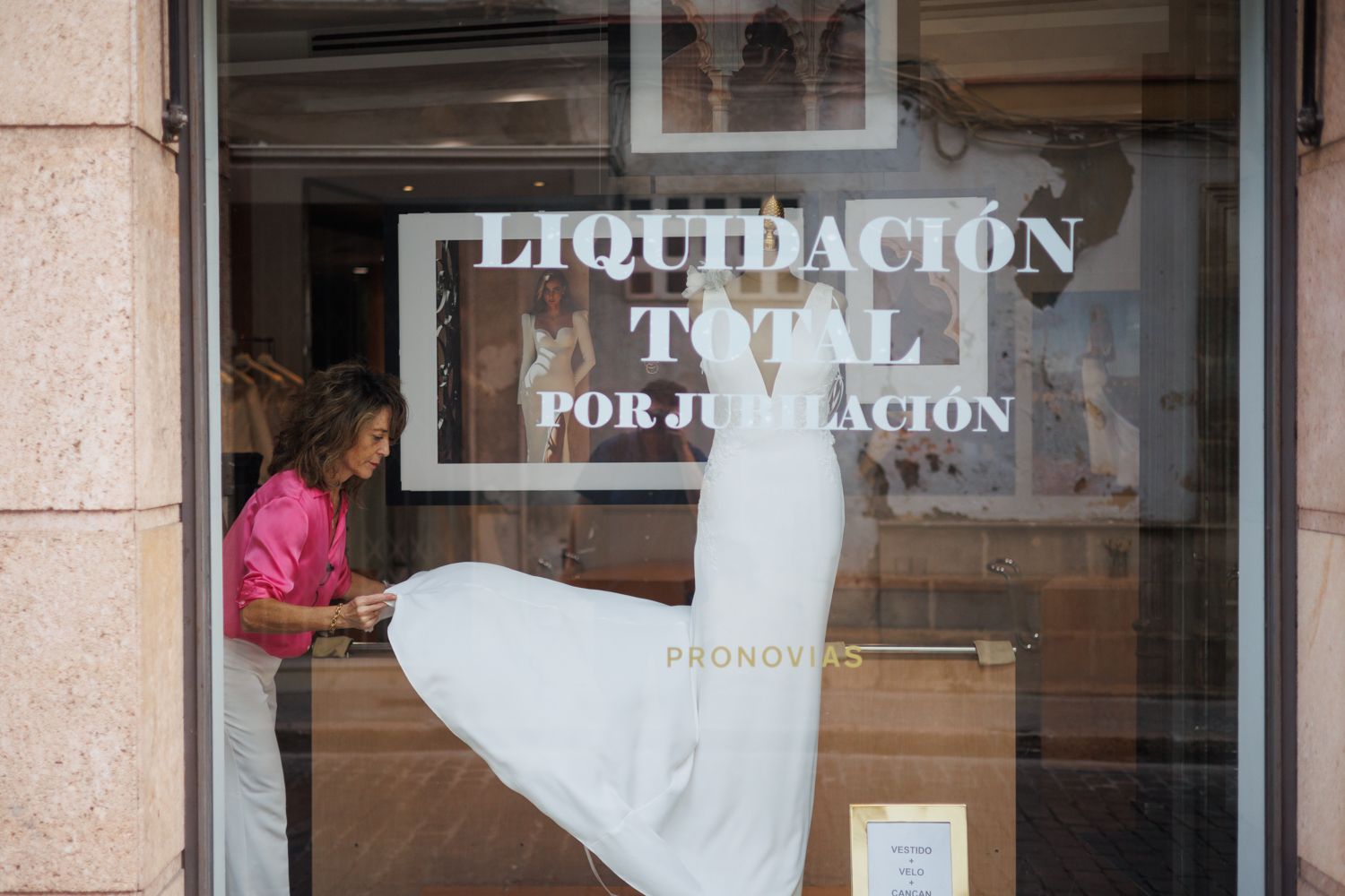 Monica Iñigo arreglando un escaparte de Pronovias en el que se anuncia el cierre.