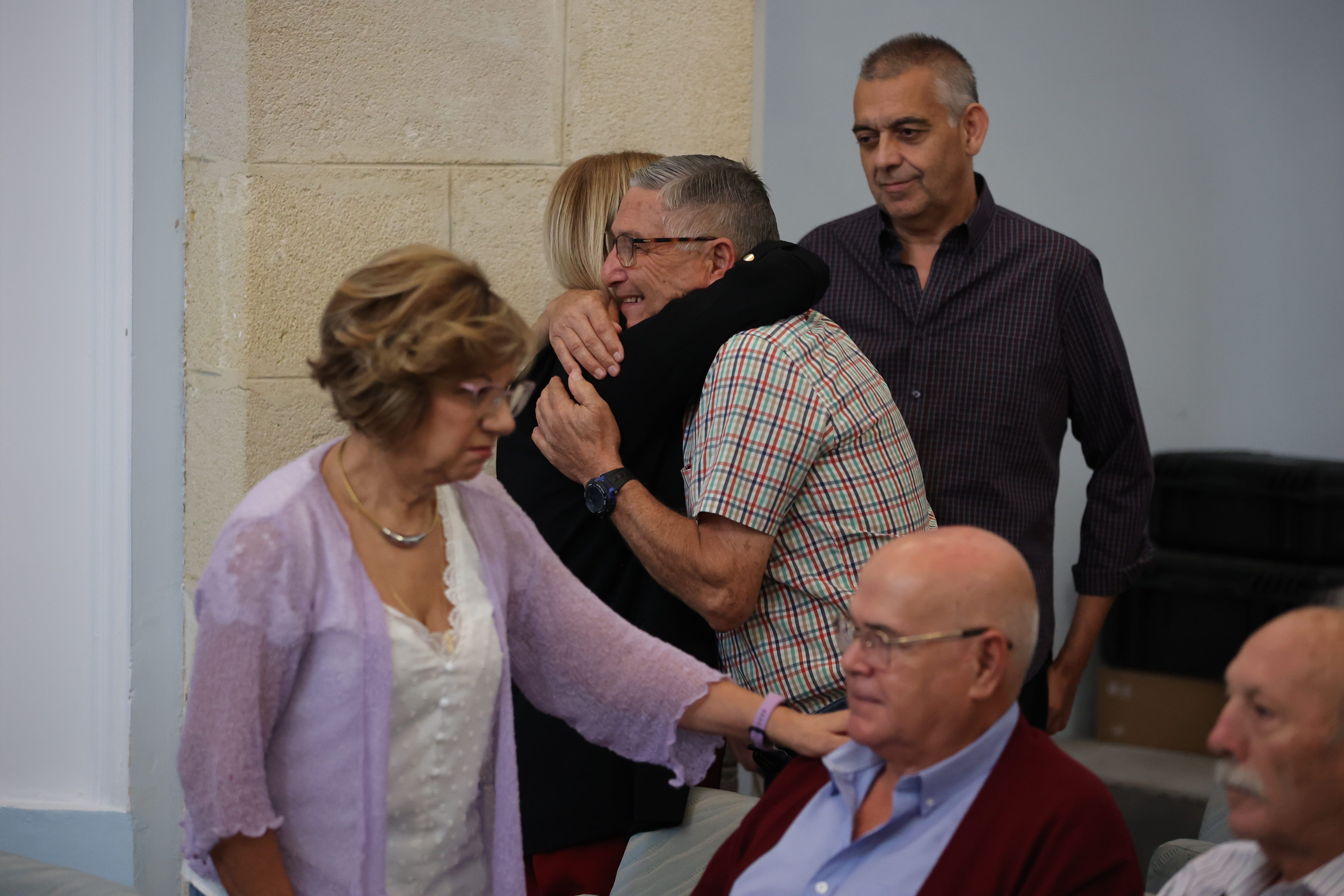 Carmen Collado, del PSOE, en primer plano, y María José García-Pelayo, alcaldesa popular de Jerez, abrazando al representante del colectivo.