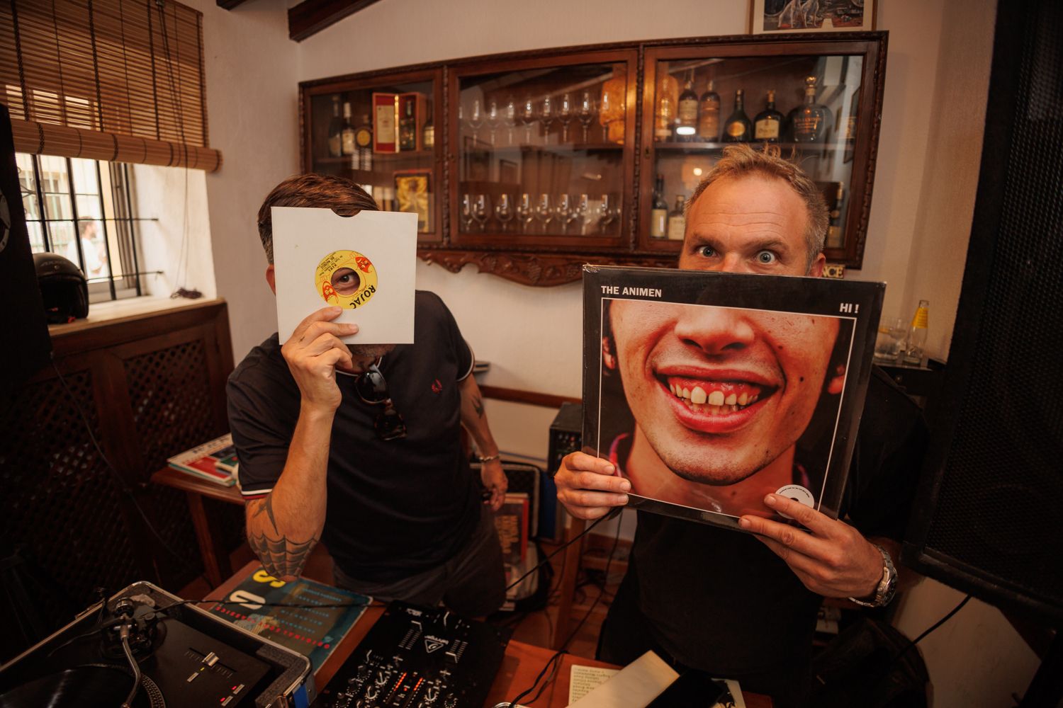 Miguel y Álvaro, de La Escena, sostienen dos vinilos en sus caras.