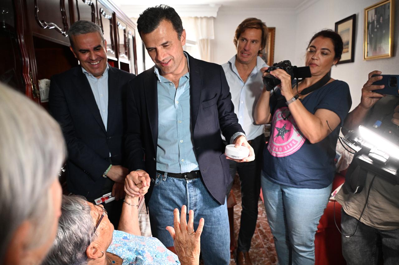 Bruno García le entrega un detector de humo a una persona mayor esta mañana en Cádiz.