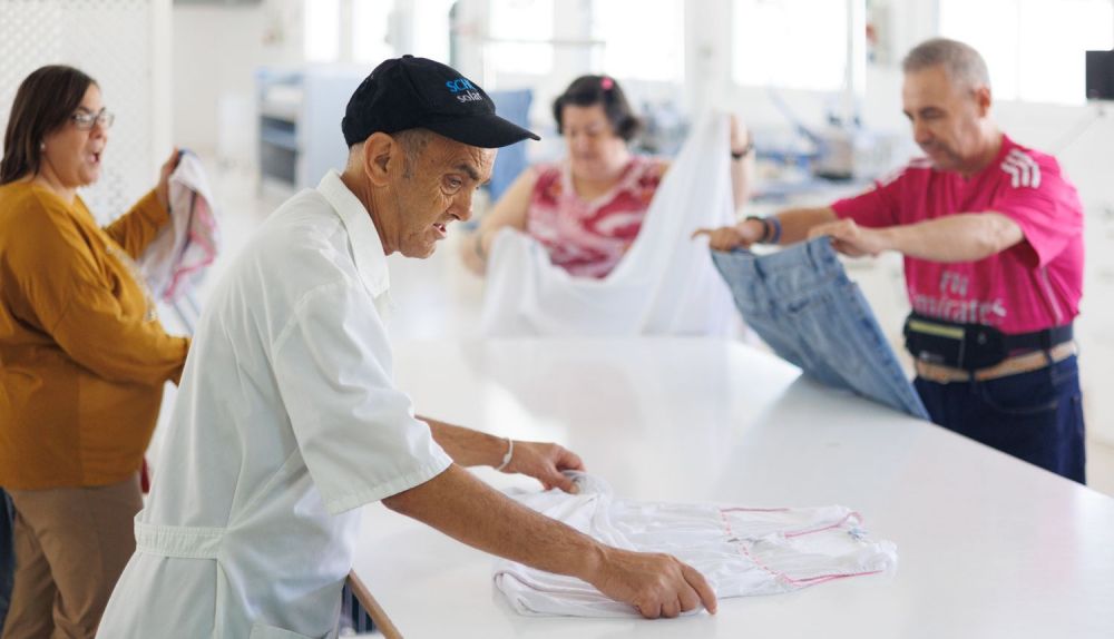 Varias personas preparan la ropa.