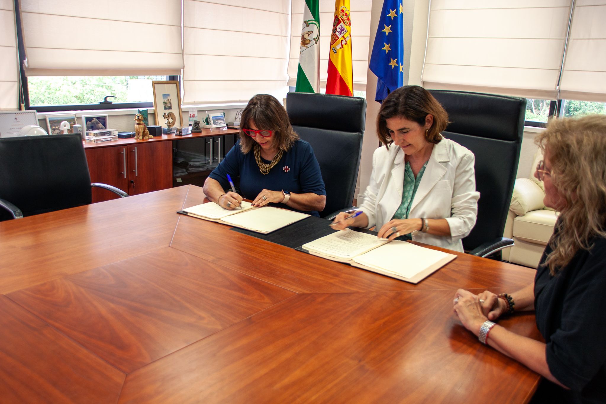 La consejera y la presidenta de la Cruz Roja en la firma del convenio. 