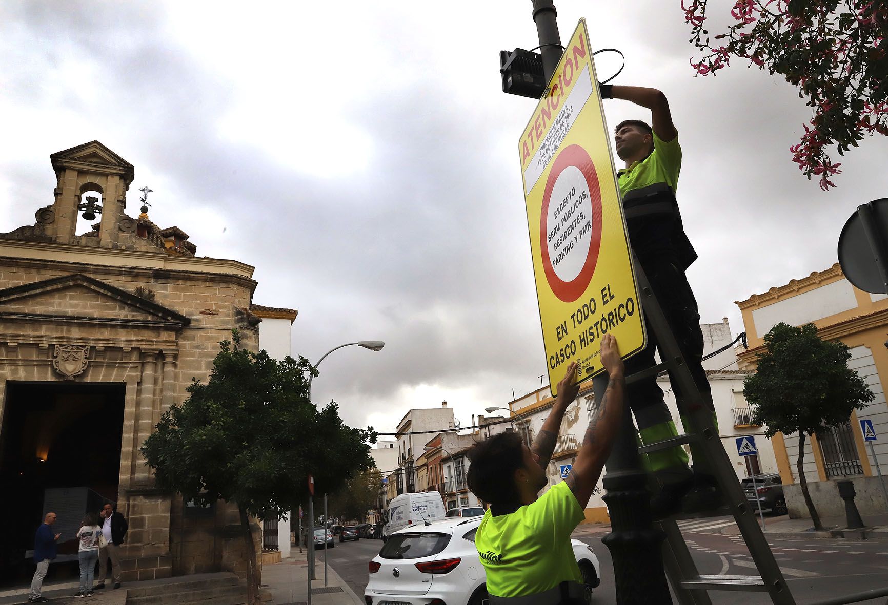 Un operario municipal, con un cartel que prohibe el aparcamiento en el centro de Jerez.