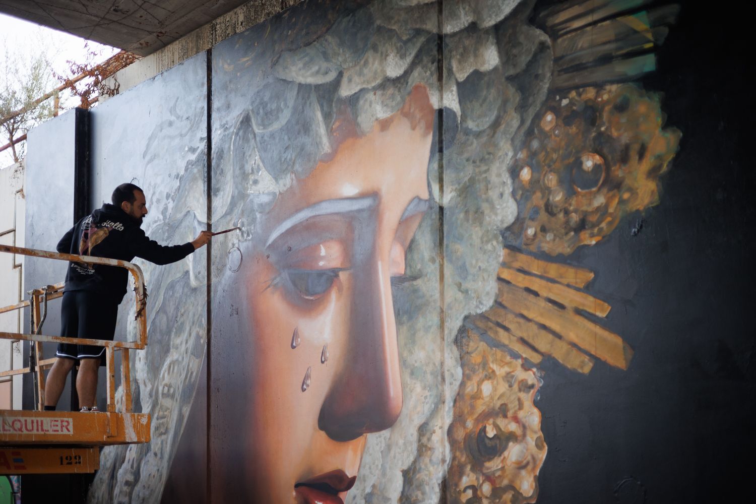 Pol Tatoo en el puente de la calle Arcos rematando detalles del rostro de la Dolorosa de las Viñas. 