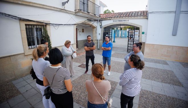 Madres y padres afectados dialogan en la puerta del colegio.