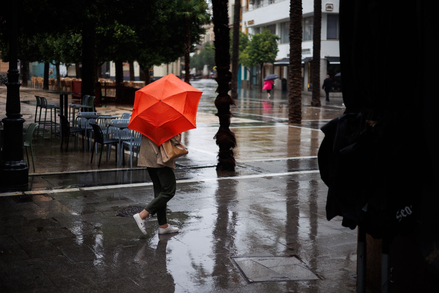 Un peatón se refugia de la lluvia con un paraguas, esta semana.